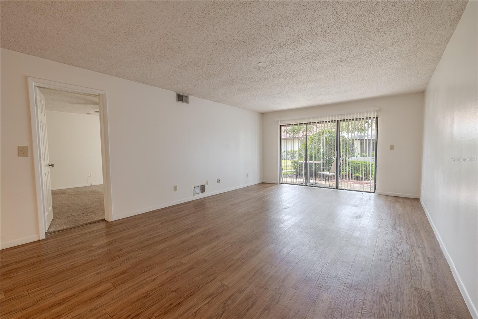 The living room has sliding glass doors that lead to the back patio.