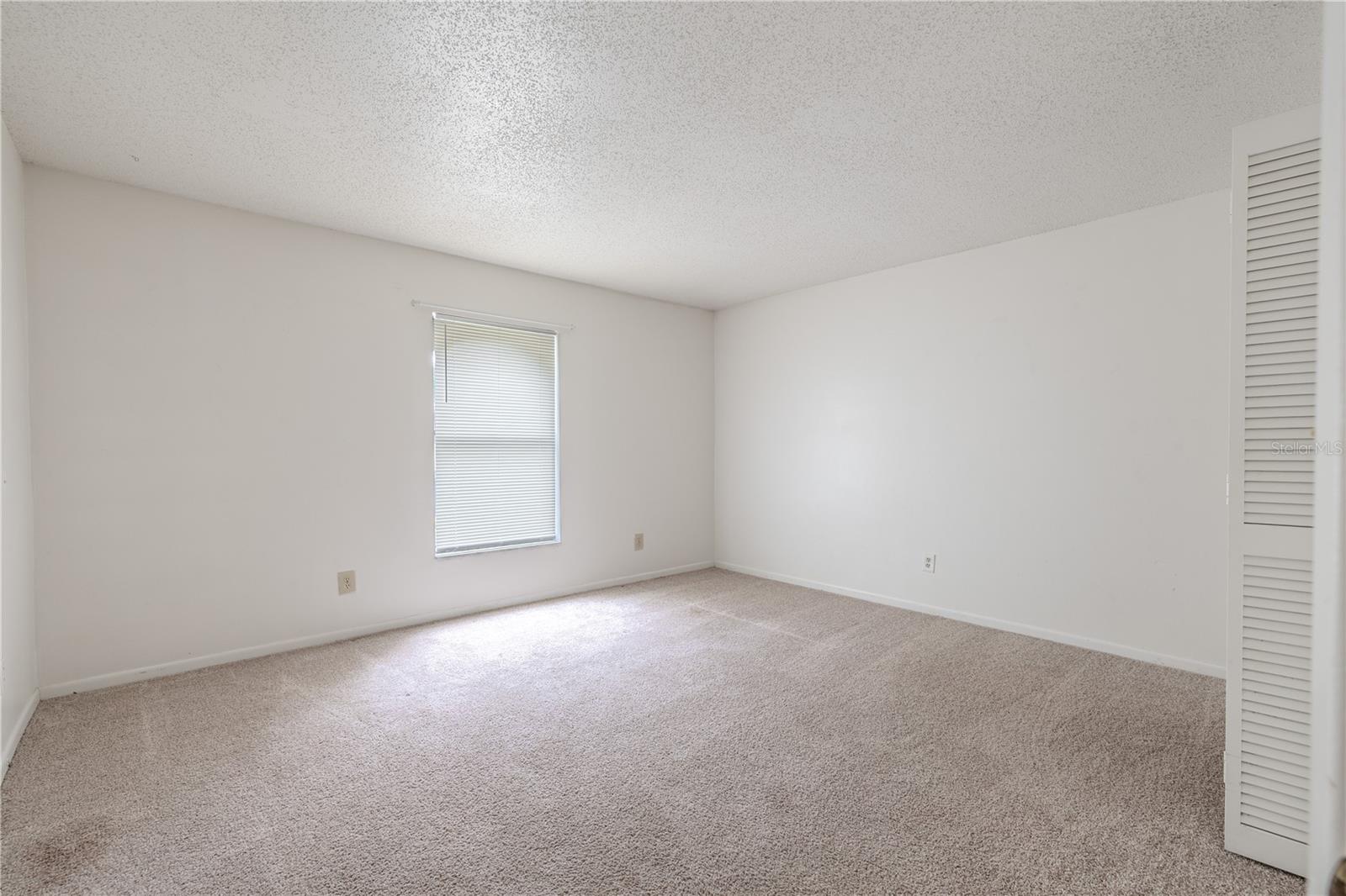 2nd bedroom features a neutral color palette and carpet.