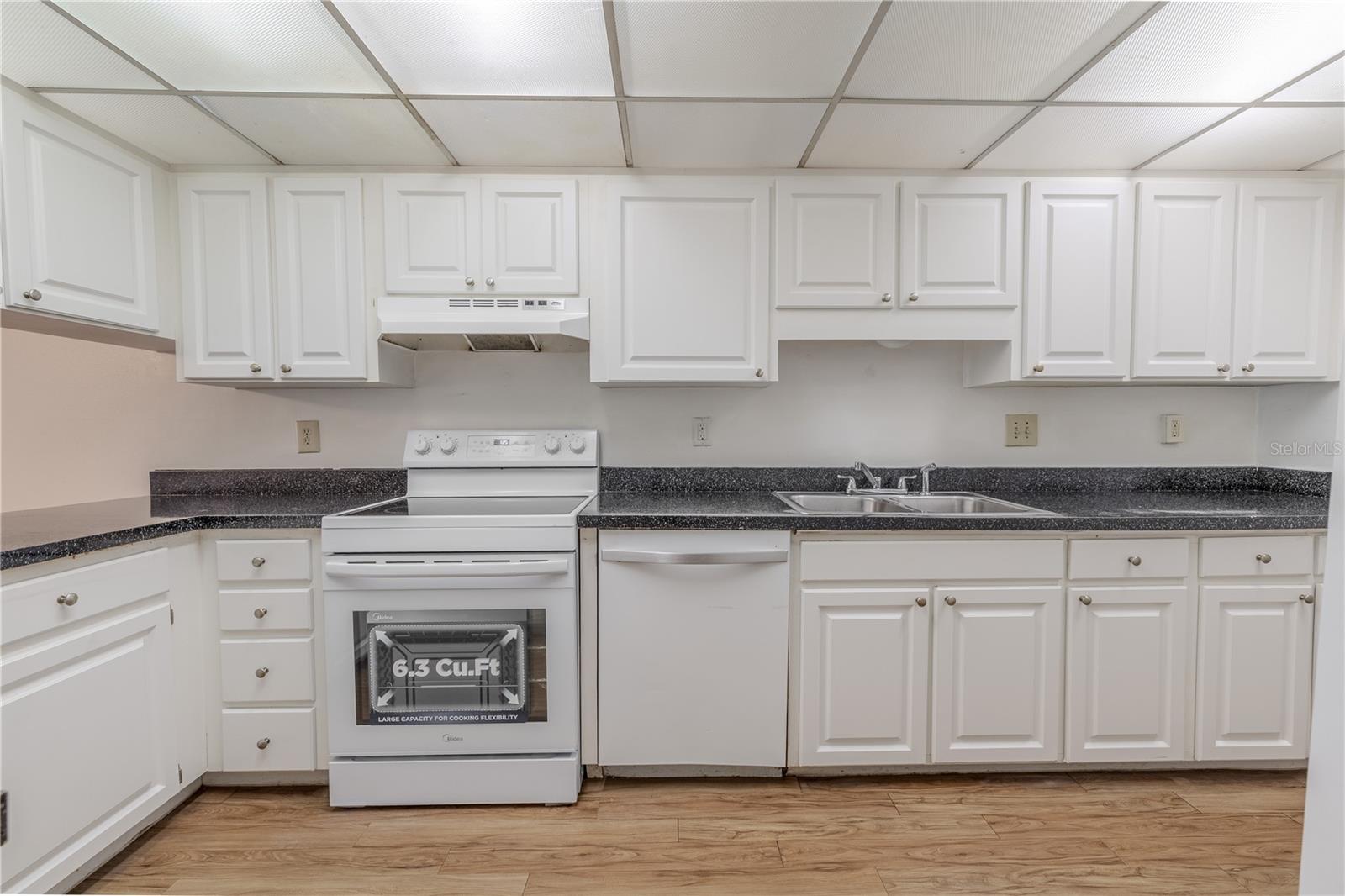 The kitchen features overhead lighting, an abundance of cabinets, drawers and counterspace.