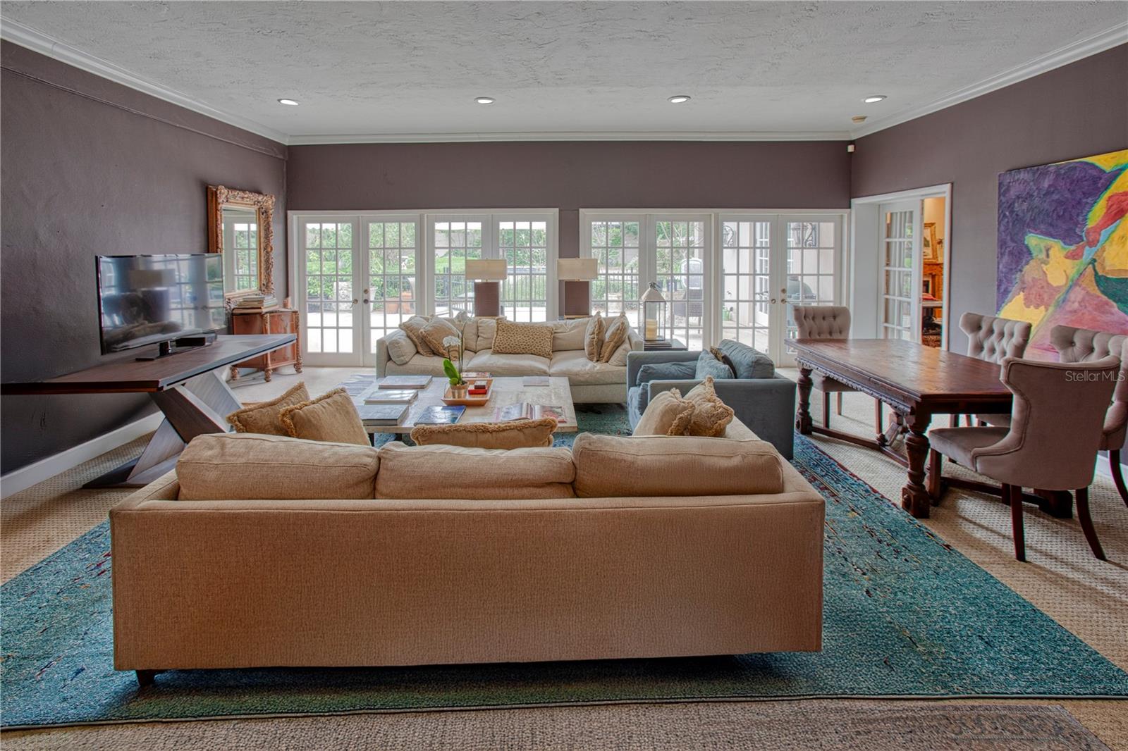 The great room has french doors that span the entire width to the outside entertaining area