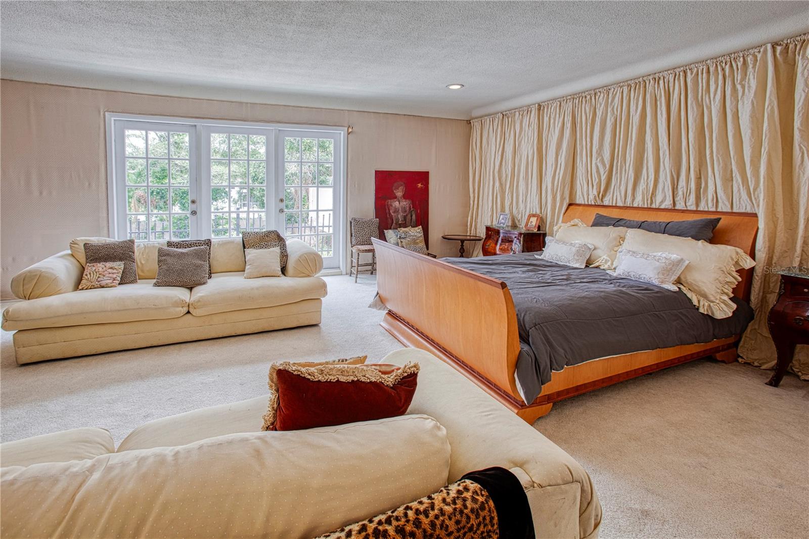 The upstairs primary bedroom features a balcony with french doors