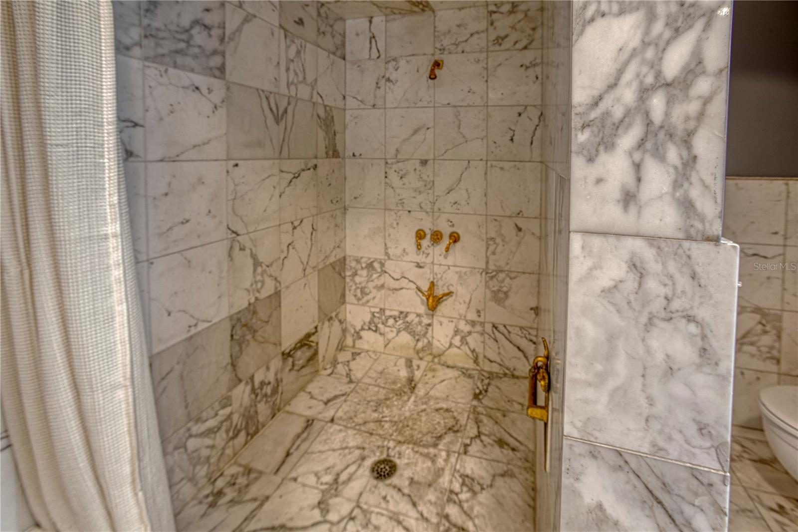 The marble walk in shower with Cheryl Wood fixtures