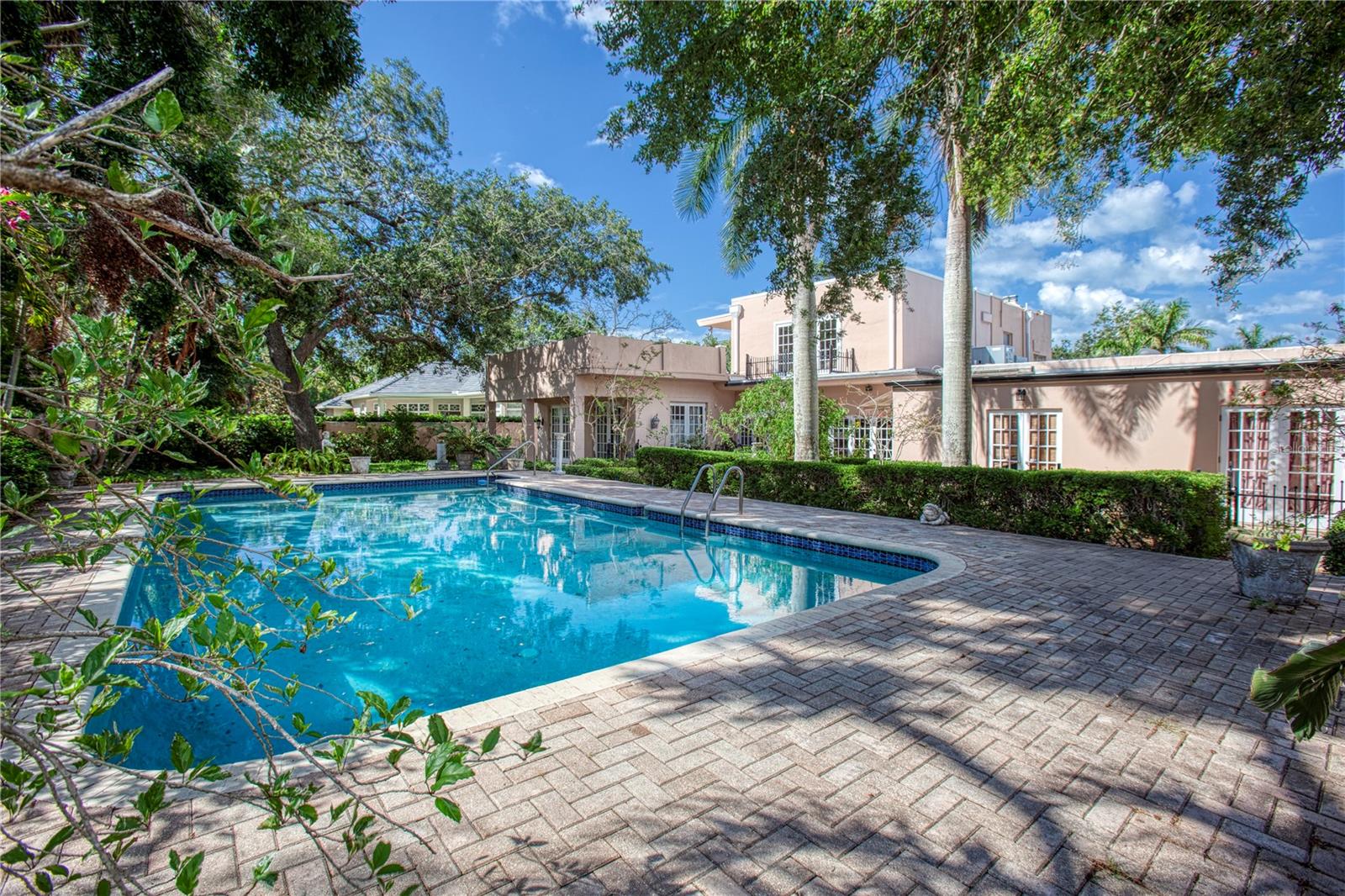 A large paver deck surrounds the pool