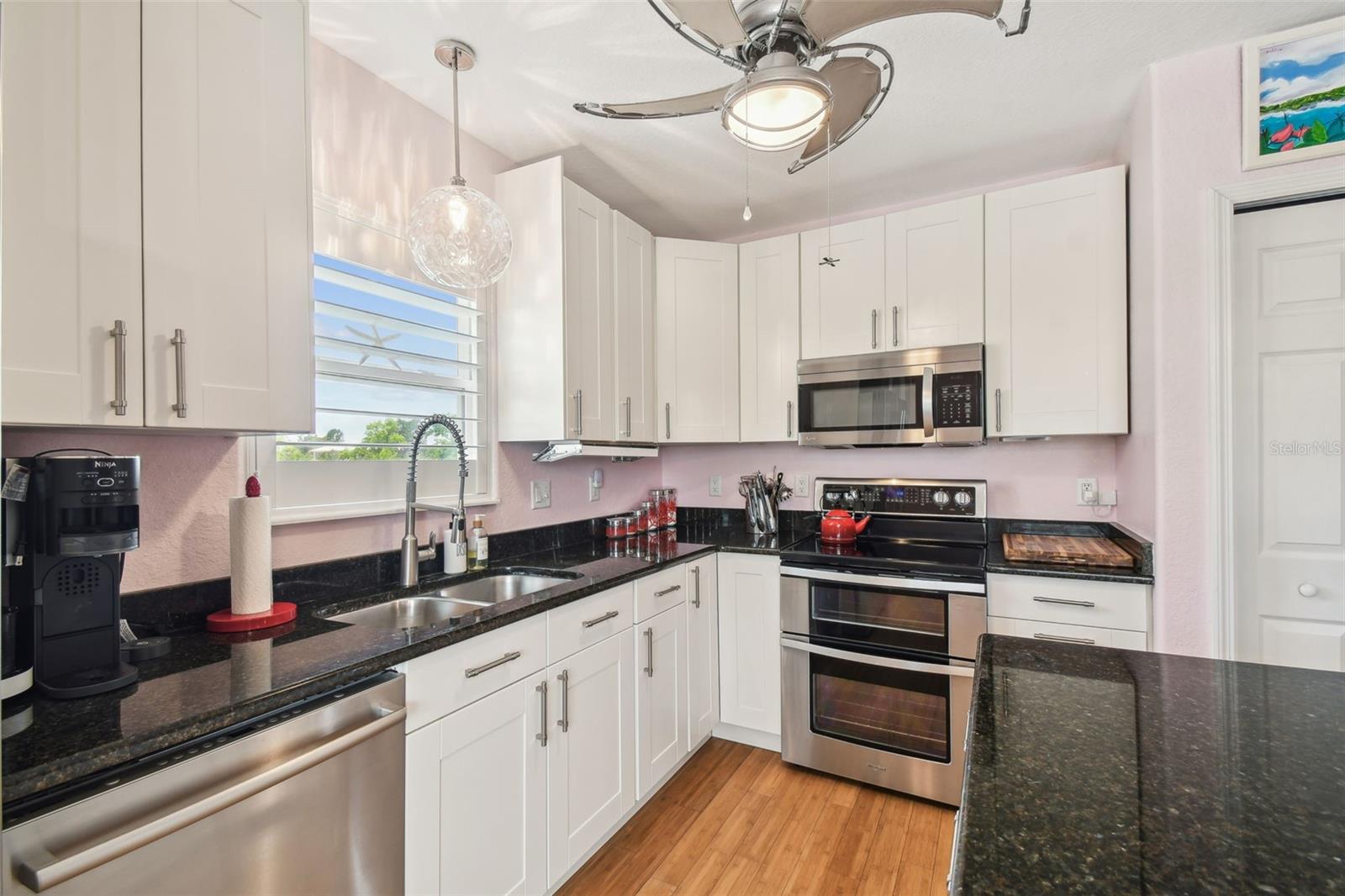 Updated kitchen featuring granite countertops, stainless steel appliances, double oven, soft close cabinets overlooking the living and dining area.