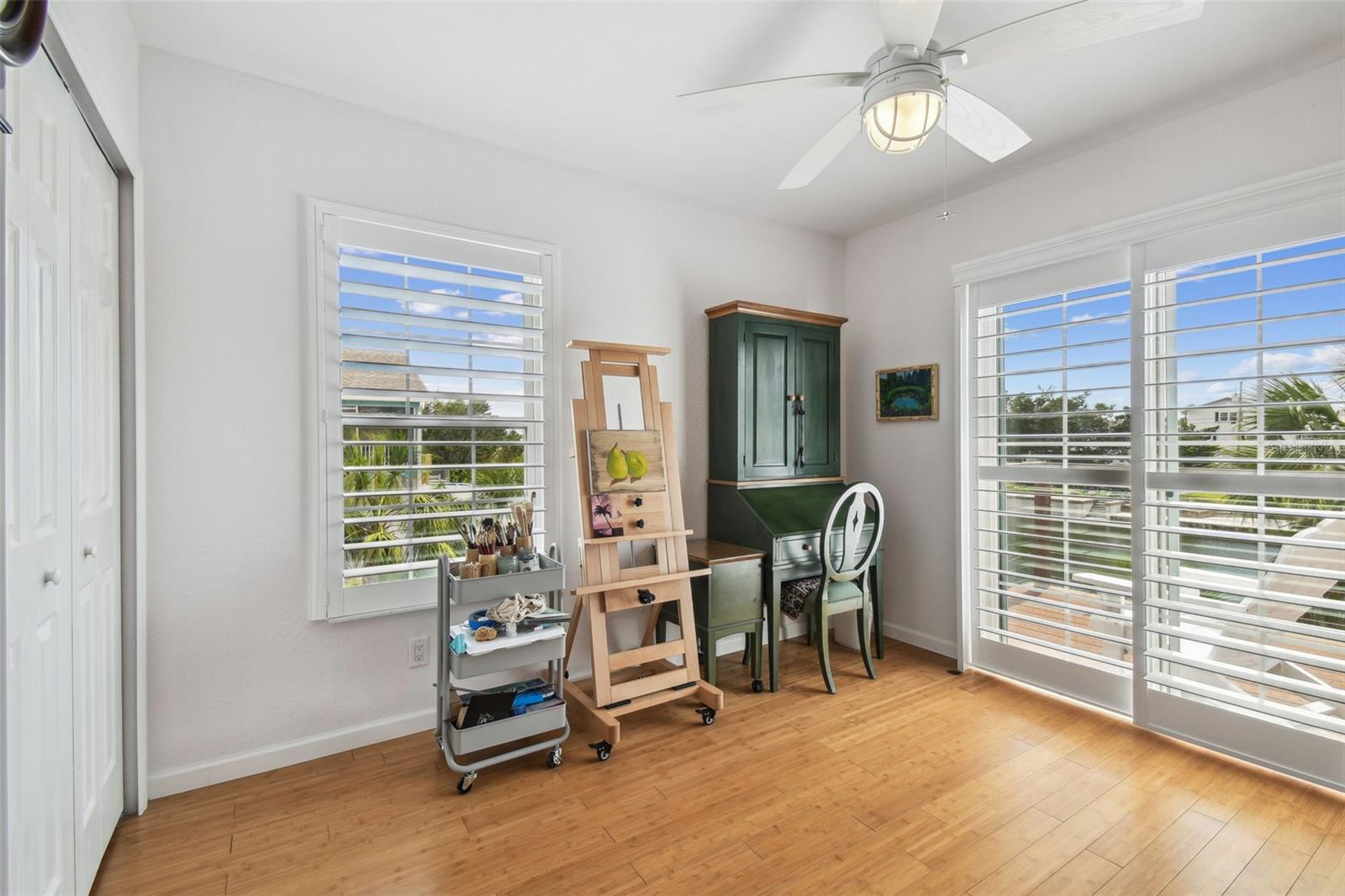 Art room with sliding glass doors to the balcony; overlooking 100 feet of waterfront.  The window and doors have plantation shutters and natural sunlight pouring in.