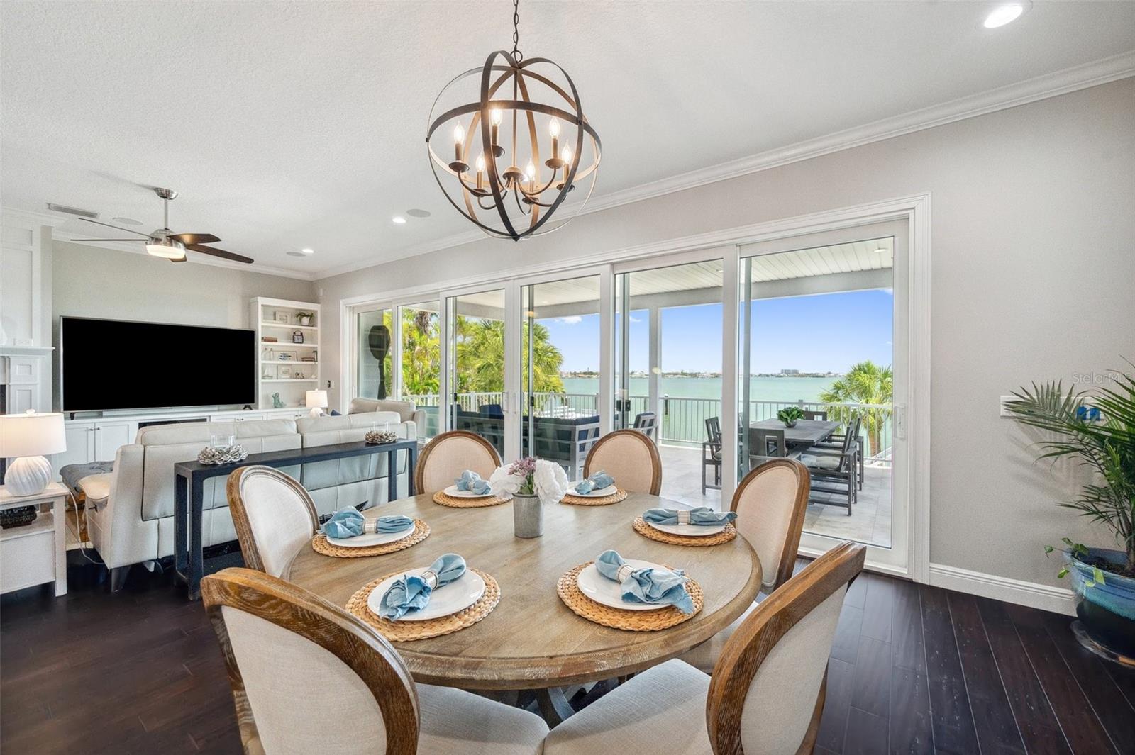 View from dining room toward the backyard and intracoastal water beyond. Here you can also see the large travertine tiled balcony.