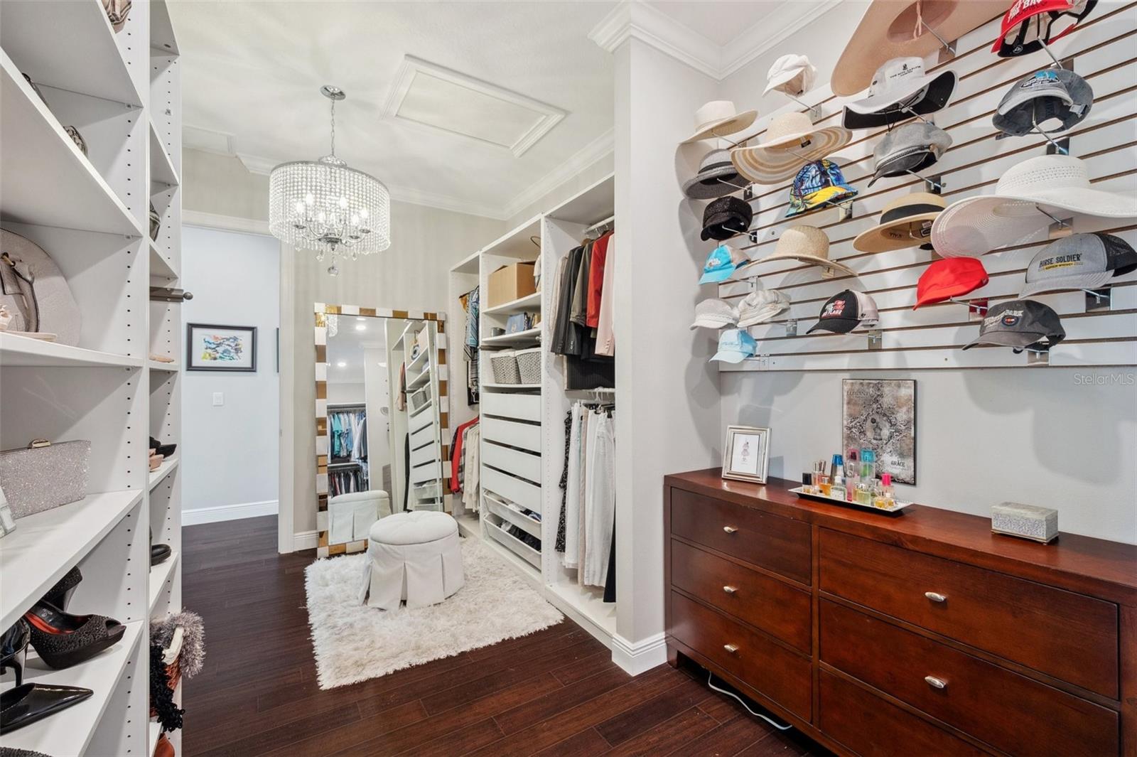 Custom master closet with tons of adjustable shelves, drawers, retractable tailor rods, hat wall, and a chandelier of course!
