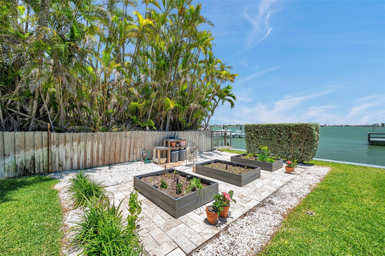 Grow a coastal garden! Three Trex garden boxes surrounded by travertine pavers (stay cooler!) that match the pool deck.