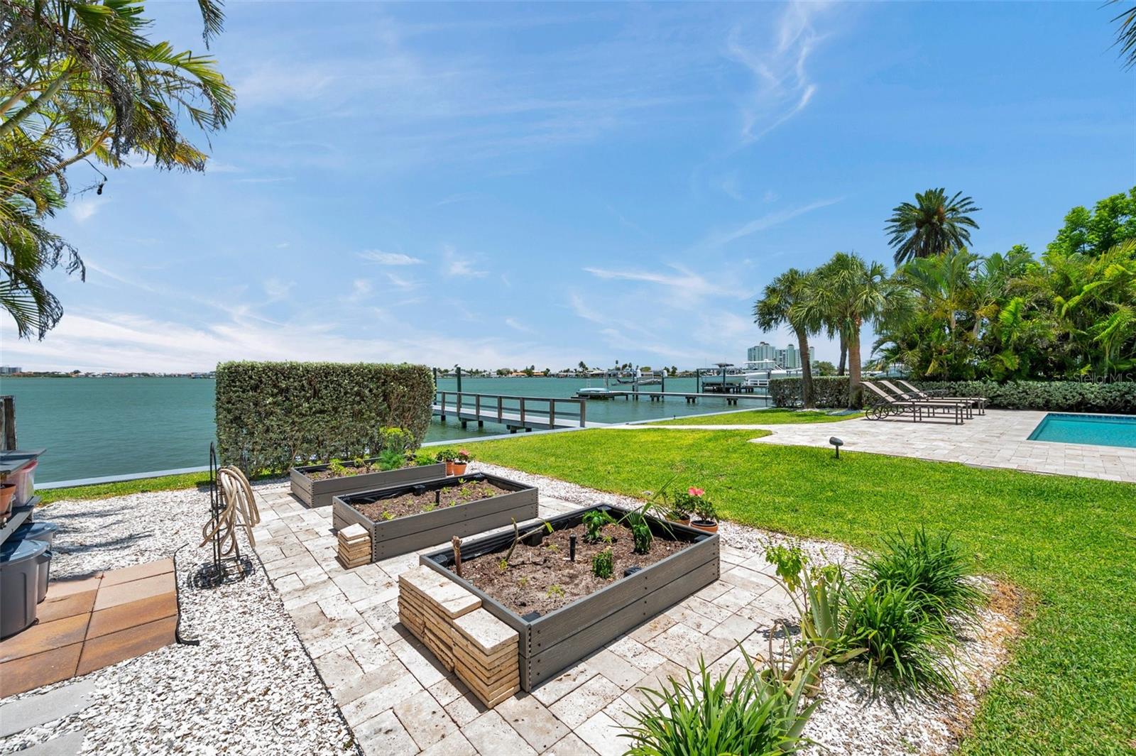 Three Trex garden boxes surrounded by travertine pavers. The hedgerow near the seawall provides some protection from wind sheer and early morning sun.