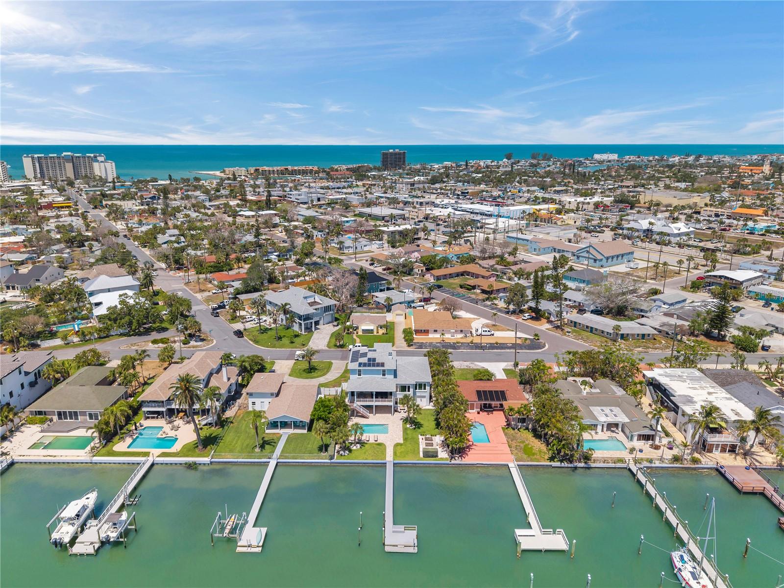 Aerial view of this St Pete Beach waterfront home showcasing the intracoastal backyard, as well as the beach that's just a short walk away.