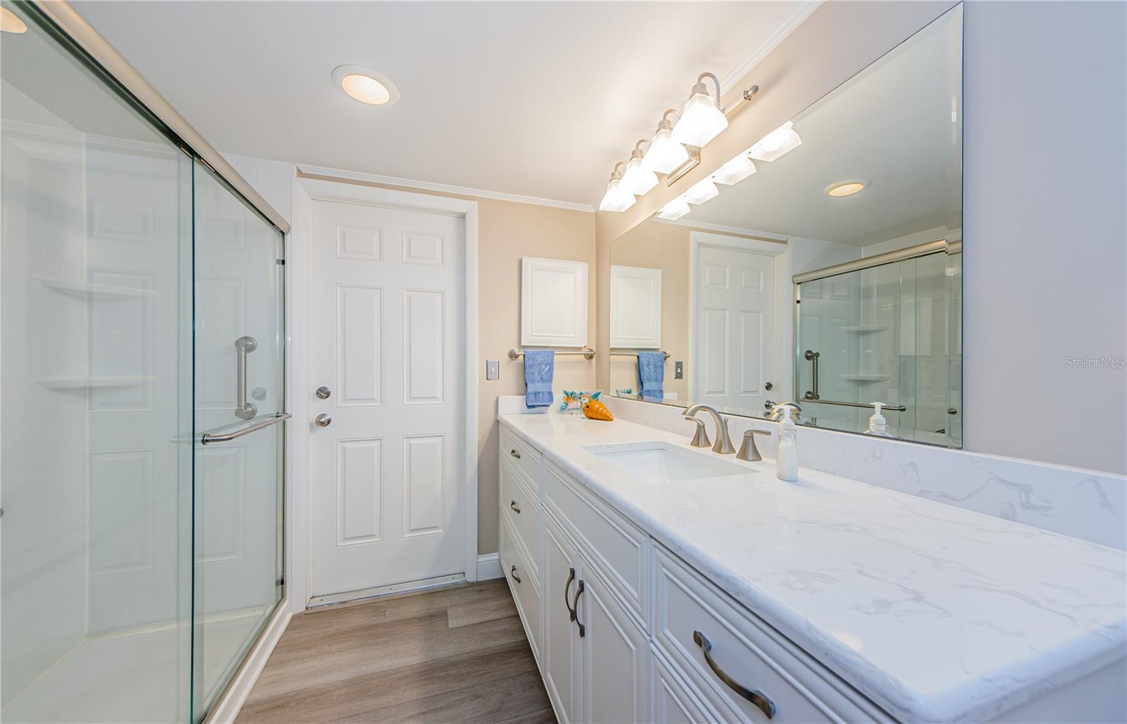 The hall bath with double vanities, Cambria quartz and a walk in shower, all fresh and sparkling clean! Door goes to side yard...