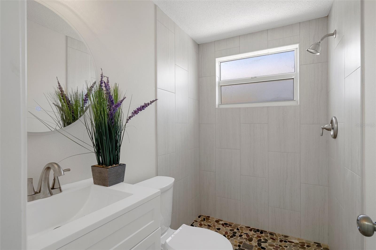 Full Bathroom near garage door and kitchen.  Check out this mirror - it lights just by touching the button on the mirror.