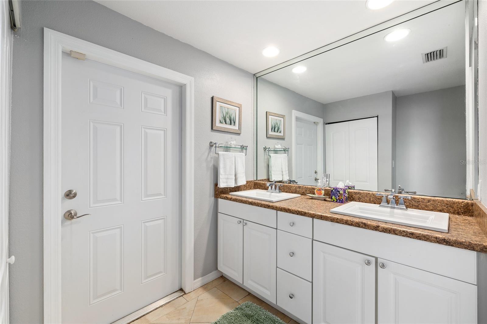 Primary Bathroom with duel sinks, tons of storage, linen closet, and door to the lanai.