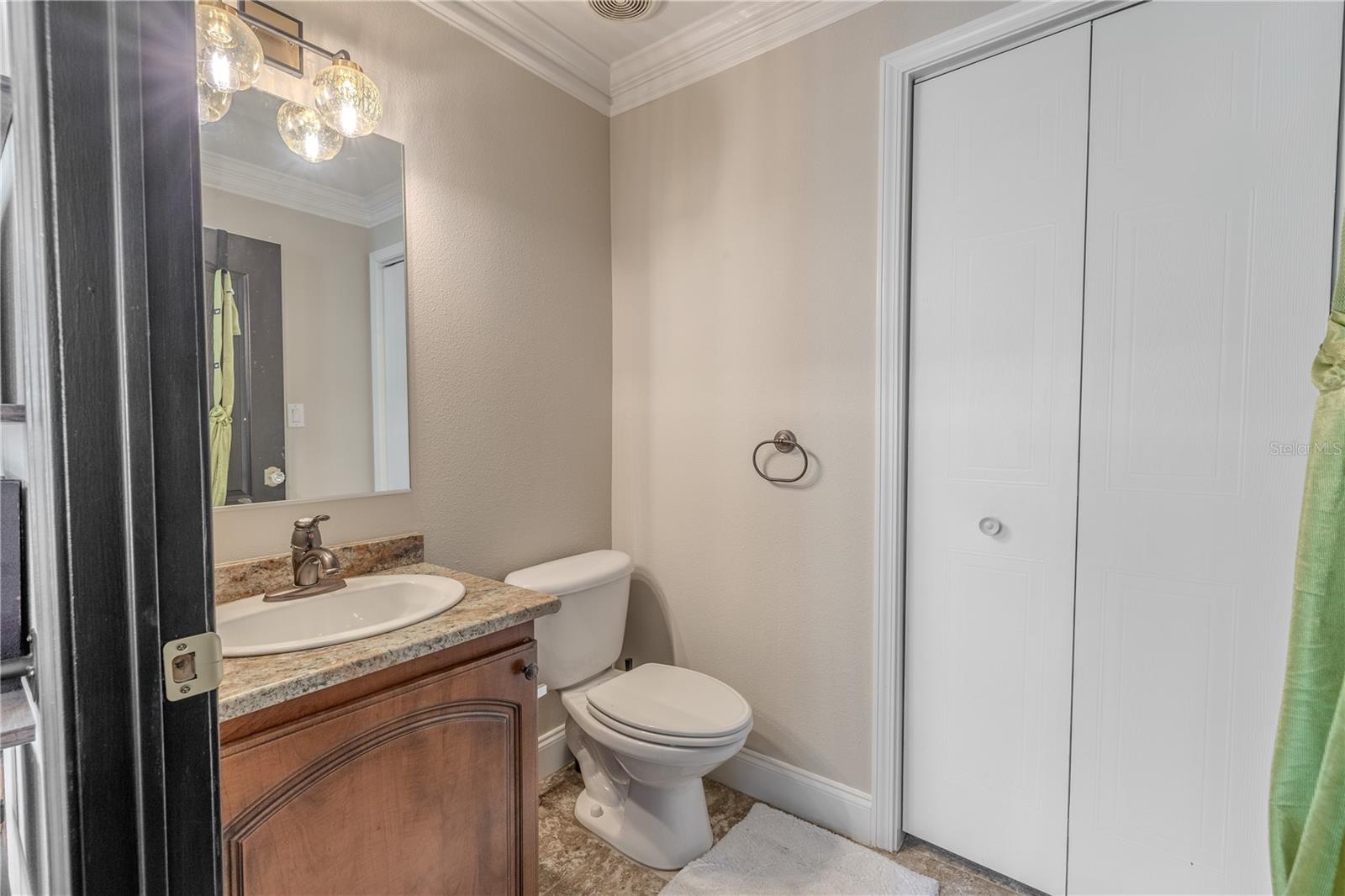 Conveniently located off the upstairs loft, this second-floor half bathroom offers style and function with easy guest access.Featuring a granite-topped vanity with warm wood cabinetry, a mirror with designer lighting, and neutral finishes throughout, this space is both practical and welcoming. Ideal for visitors or as a secondary powder room, it adds valuable convenience to the home’s upper level.