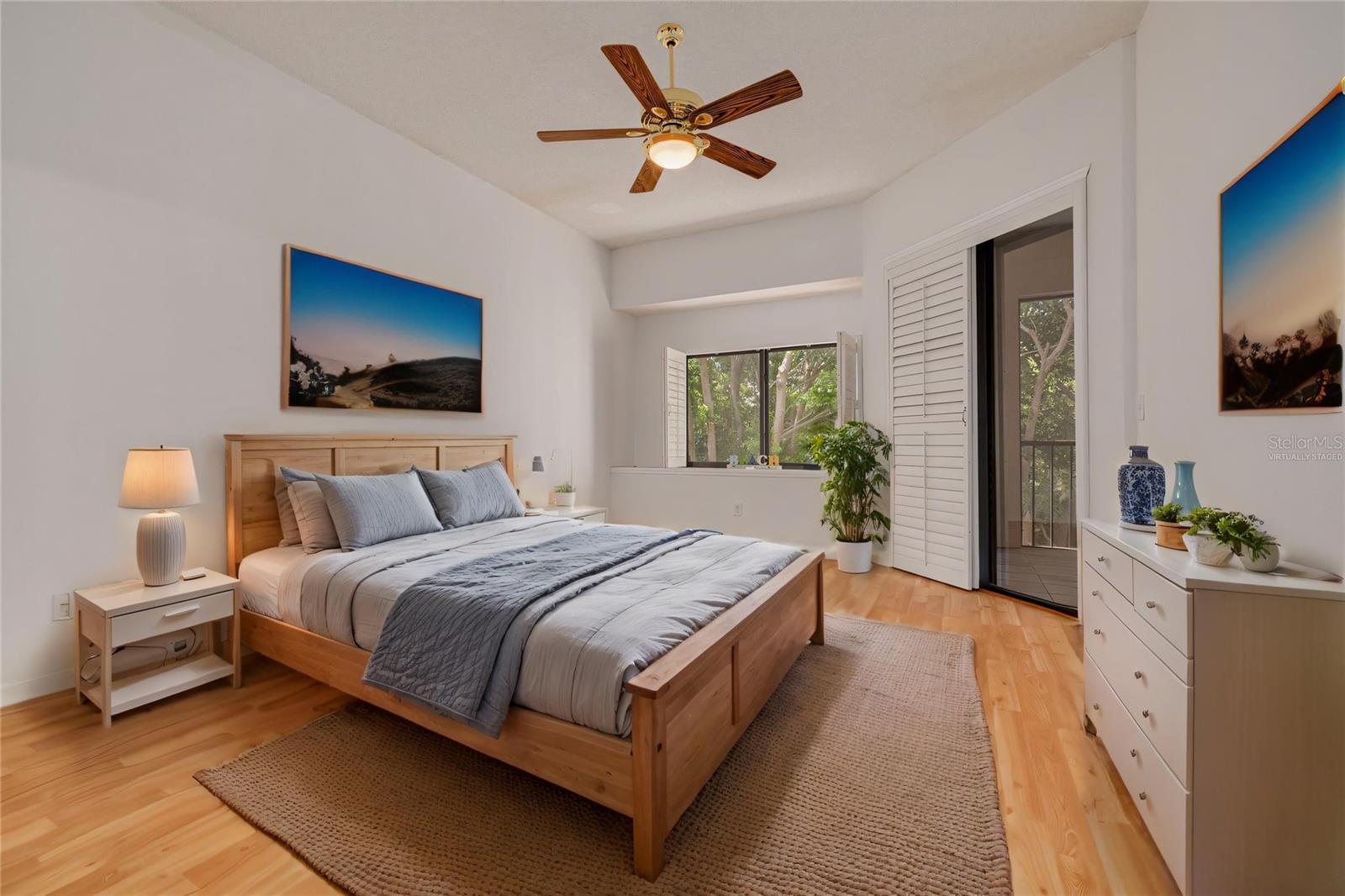 Virtually staged primary bedroom with slider to lanai on right and beautiful natural light through the large windows!