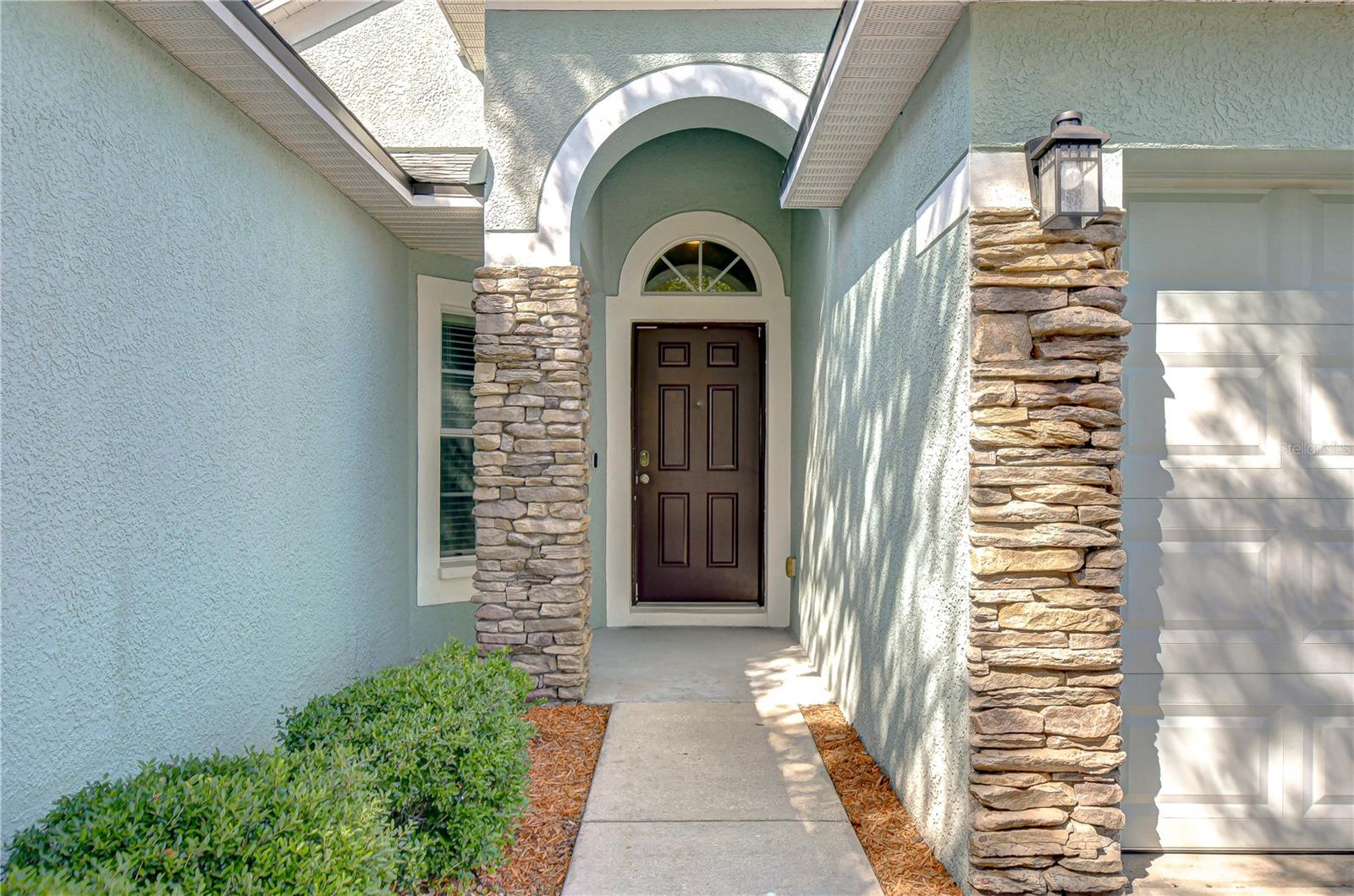Charming stacked stone accents and well-kept landscaping create inviting curb appeal!