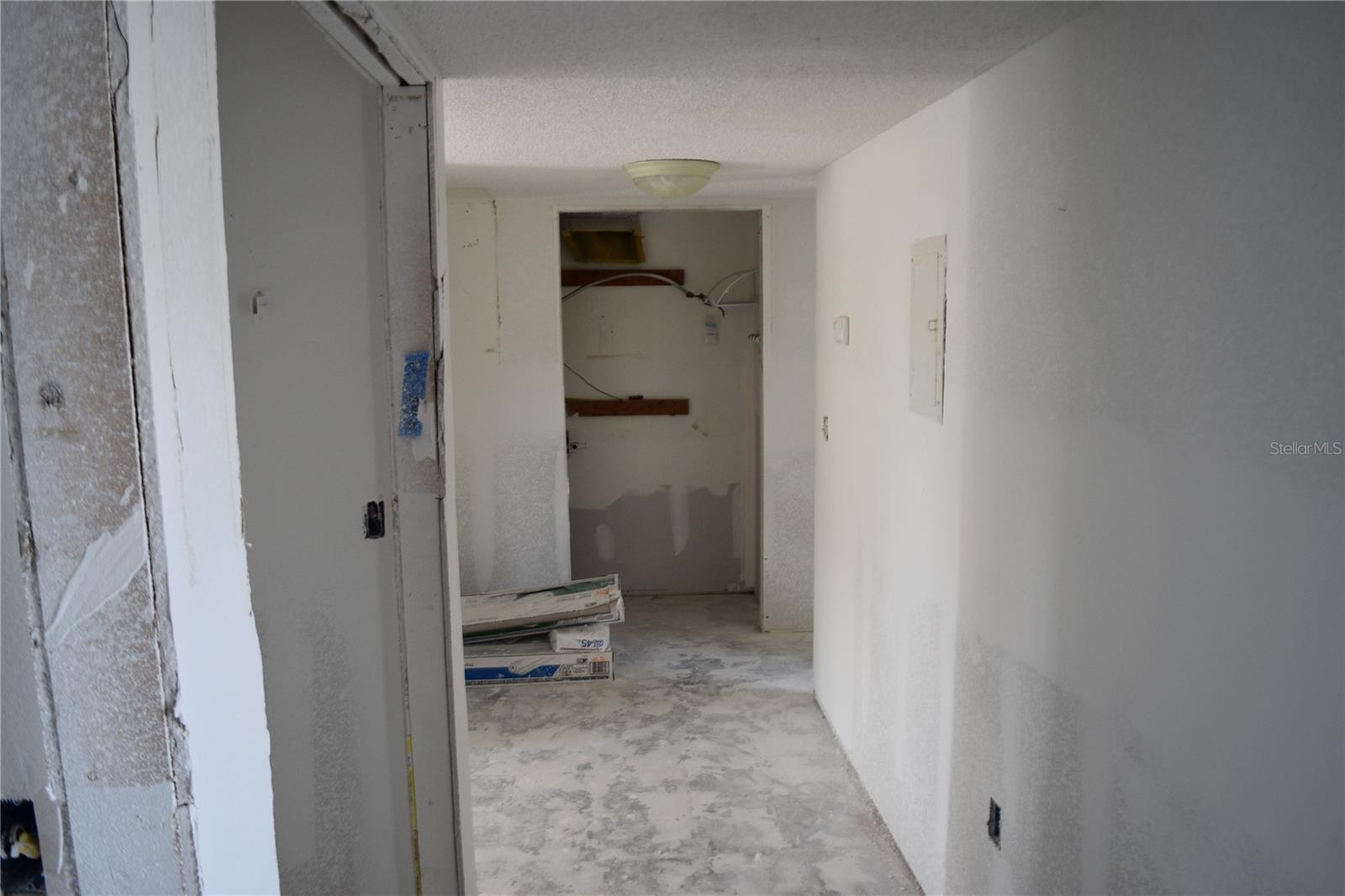 Hallway at entry door facing utility closet