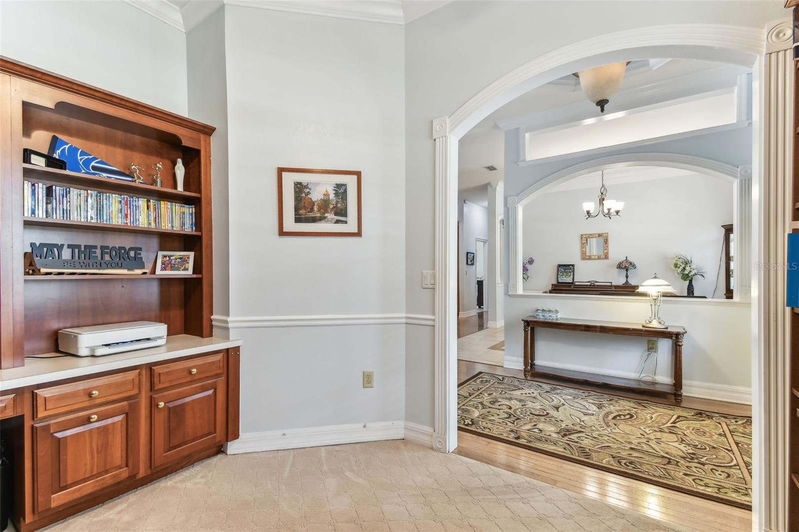 Home office space with large windows and built-in shelving, perfect for remote work or study in this Dover home.