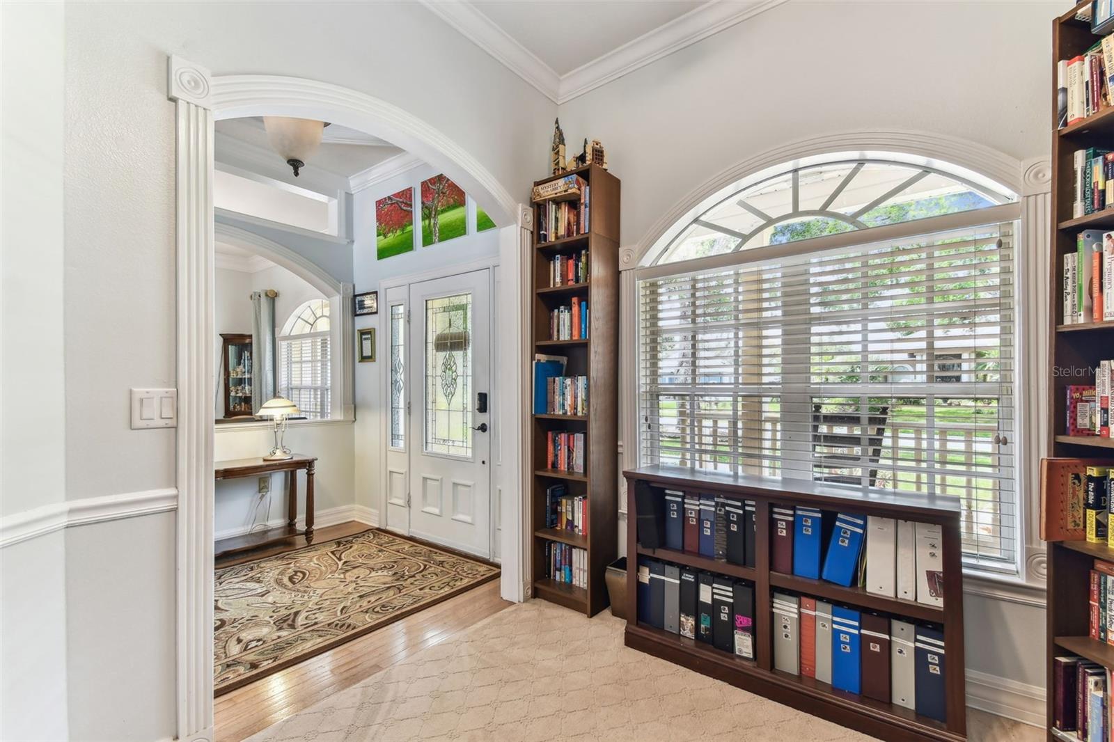 Home office space with large windows and built-in shelving, perfect for remote work or study in this Dover home.