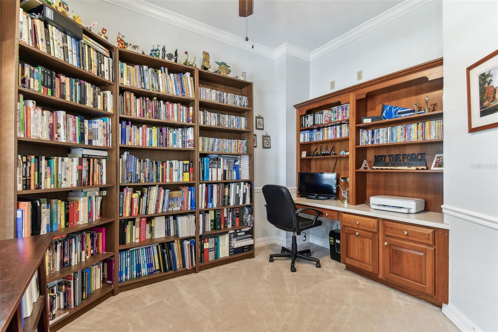 Home office space with large windows and built-in shelving, perfect for remote work or study in this Dover home.