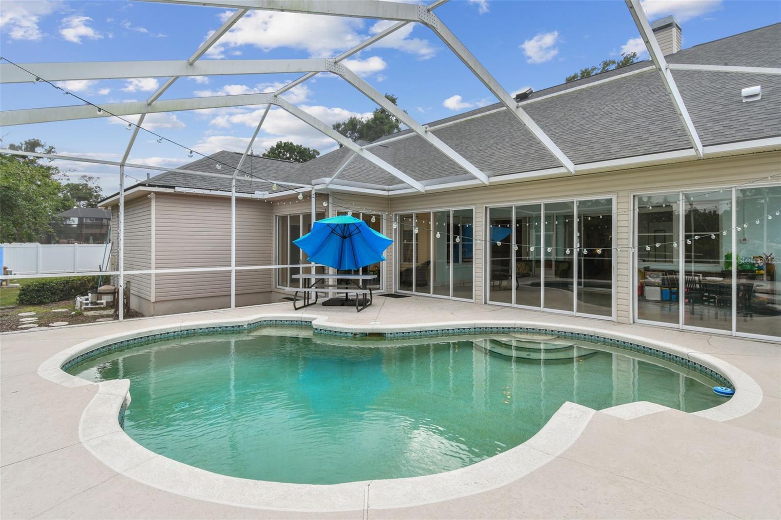 Private backyard pool with screened enclosure and patio area at 2202 Colewood Ln, perfect for Florida living and entertaining.