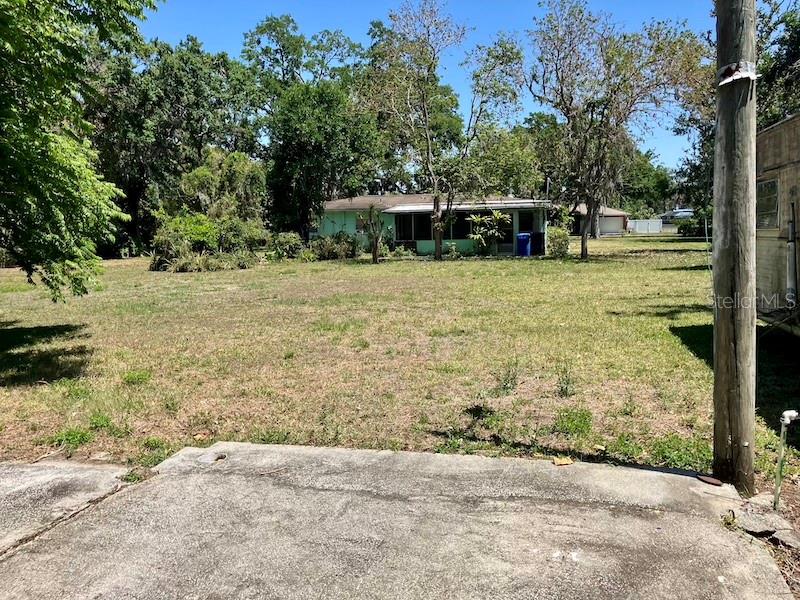 VIEW FROM CONCRETE PAD IN BACKYARD LOOKING TOWARDS HOUSE