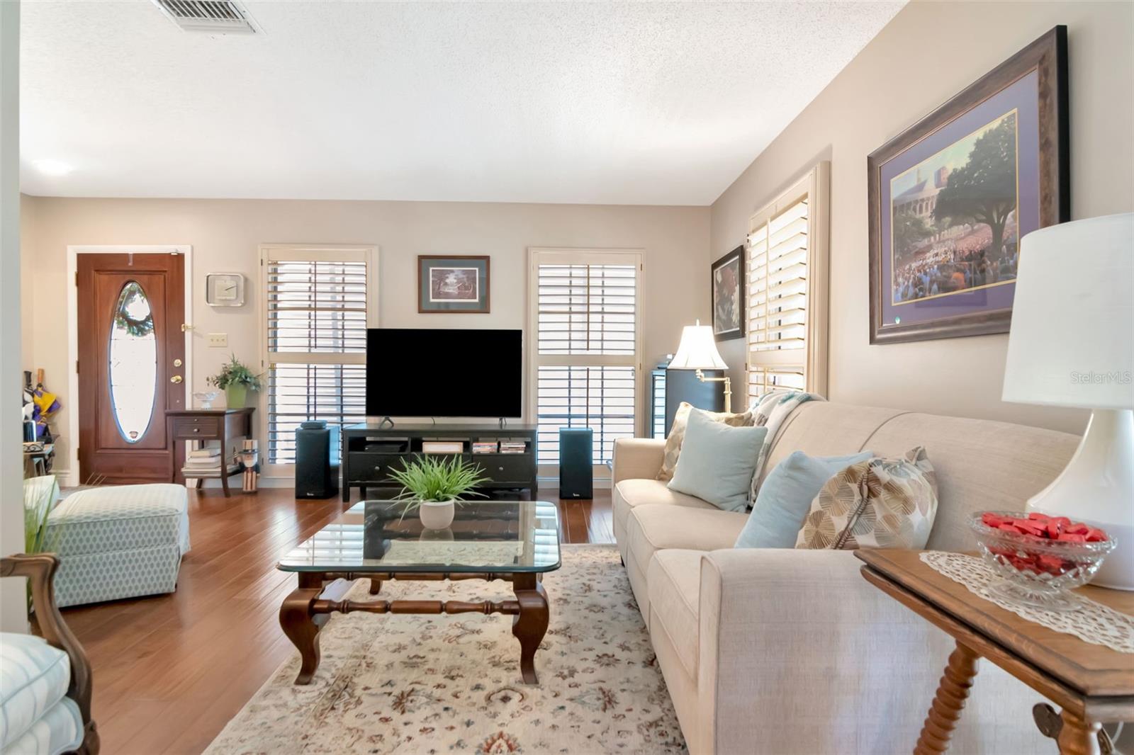 Large windows offer abundant light in your wood floored living room.