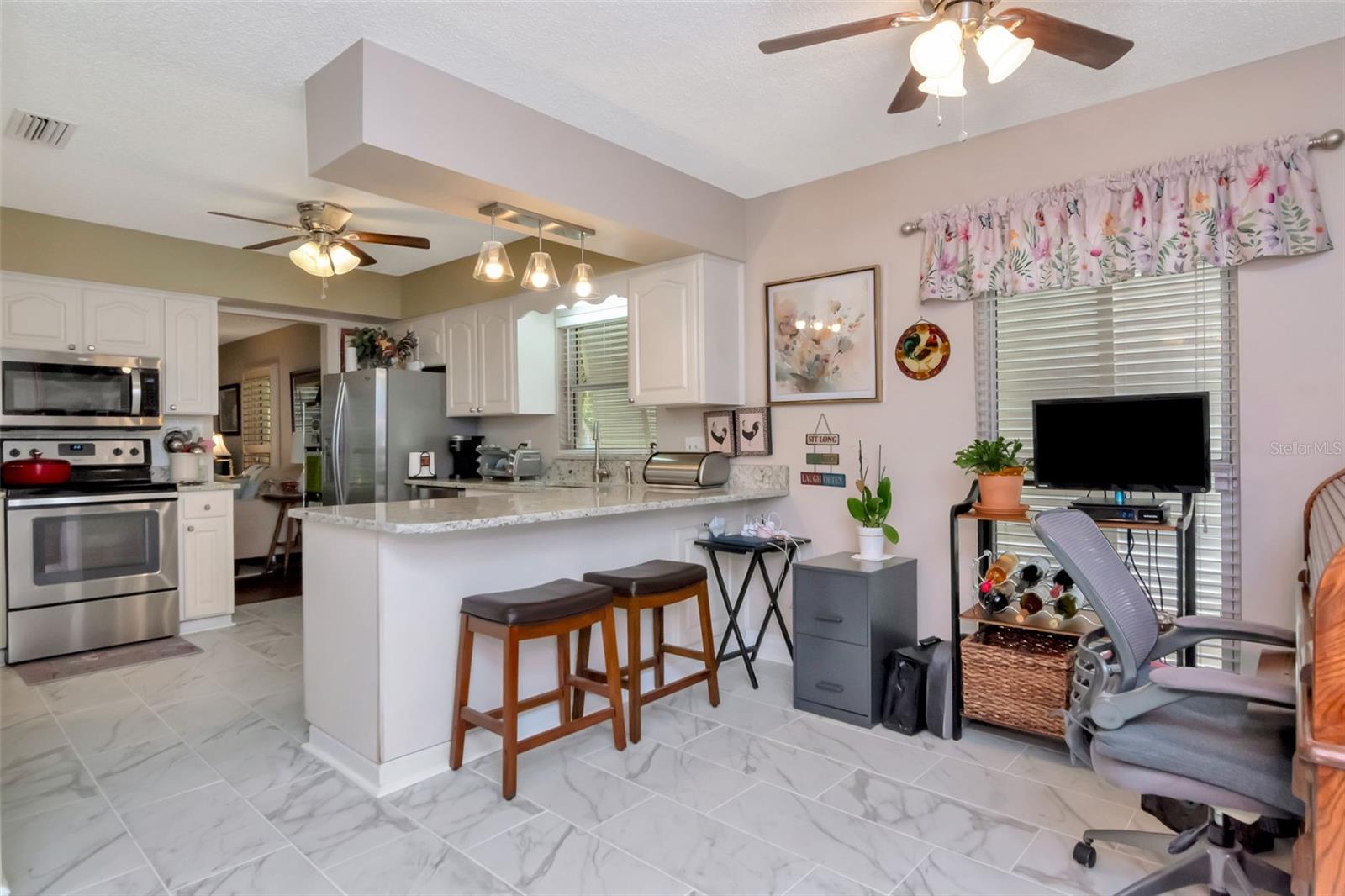 Bright kitchen with granite counters and stainless appliances opens to a family room -- or choose to add a breakfast table as well.
