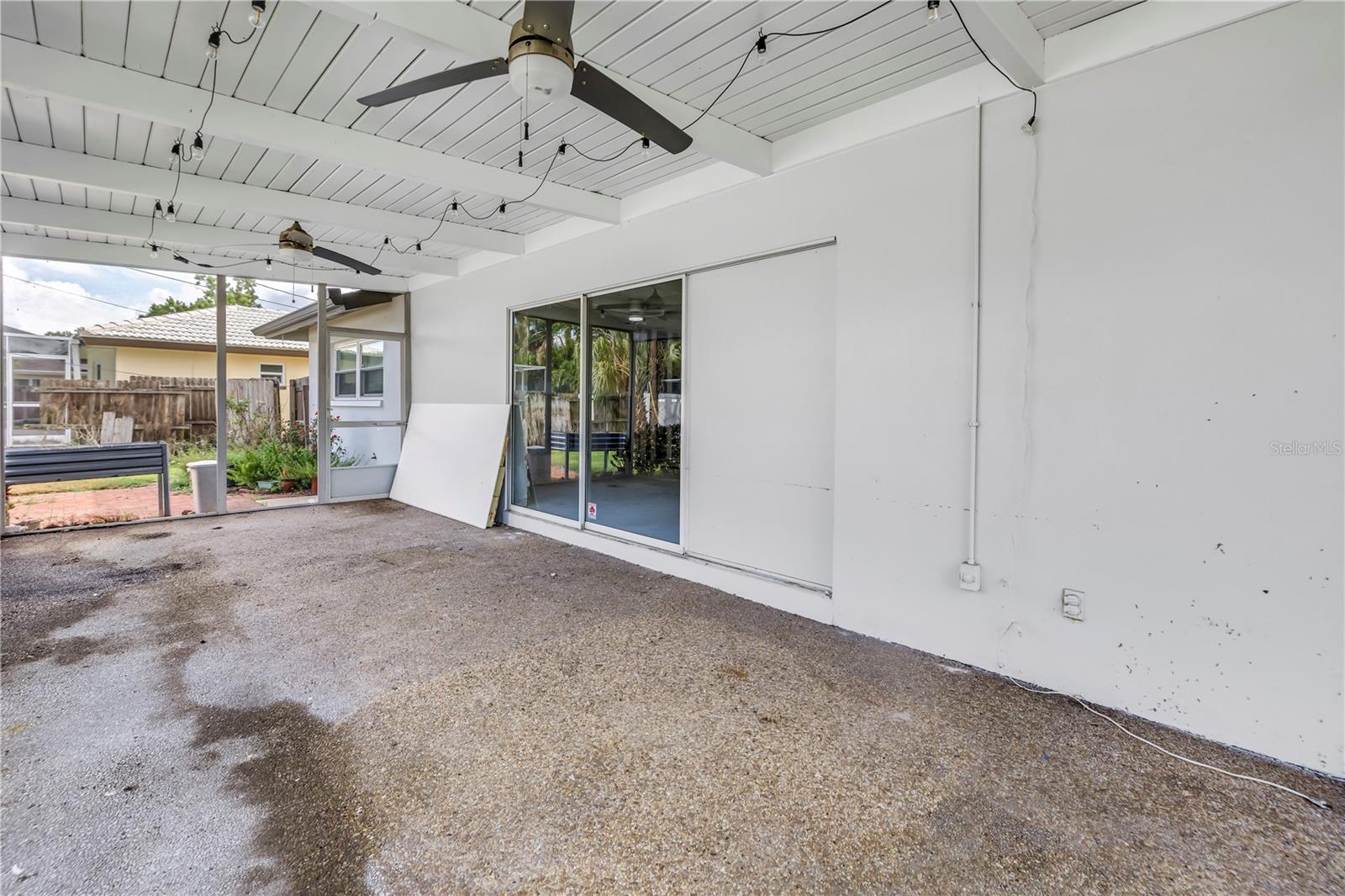 Covered rear porch with sliding doors from family room