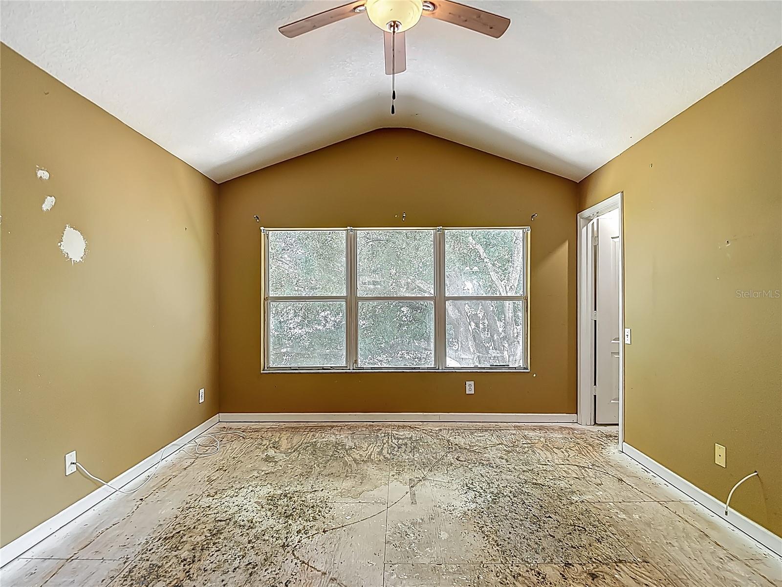 Primary Bedroom. View is west and provides a feeling of being in a tree house.  Please note the vaulted ceilings. Bath is to your immediate right. Door to the walk-in closet is in view in this pic.