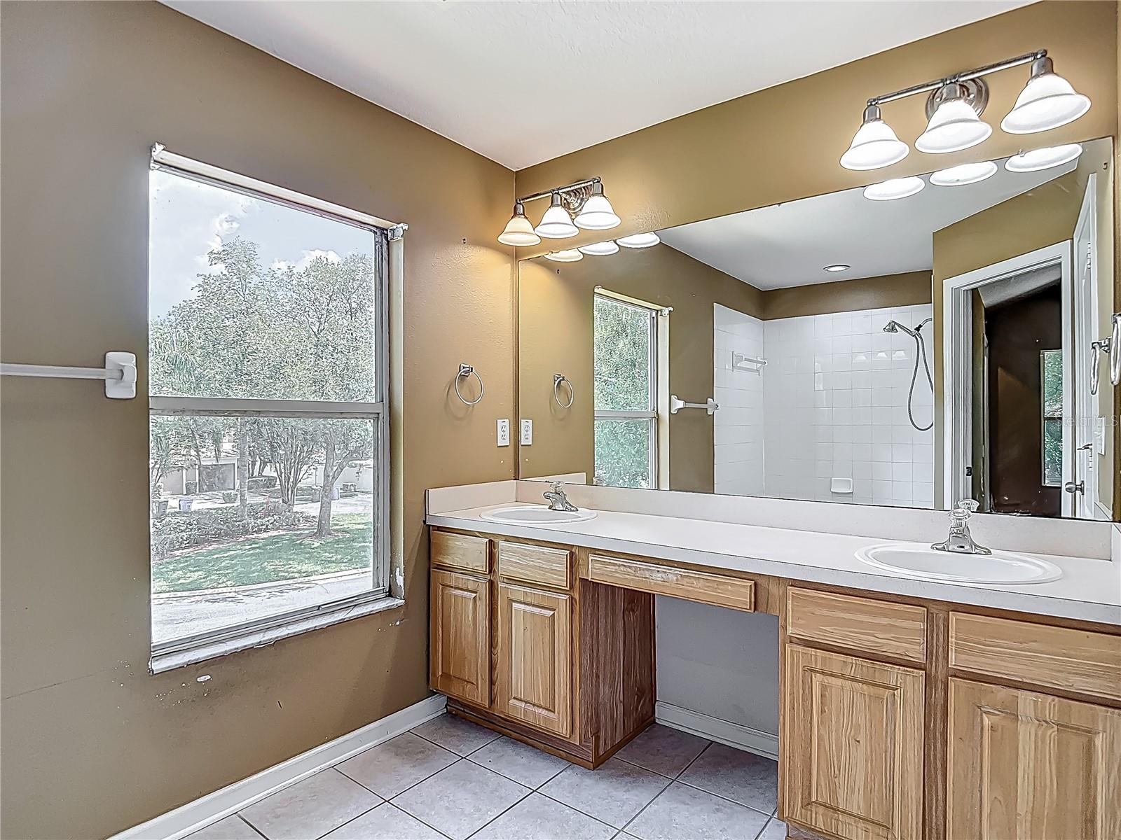Primary bedroom en-suite bath with double vanities/sinks. To the right is the private water closet. Behind you to the left is the garden tub. Window faces north.