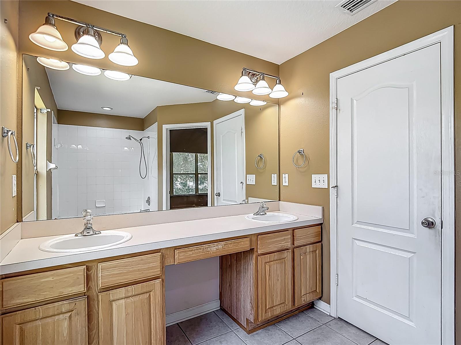 Primary bedroom en-suite bath with double vanities/sinks. The closed door is the private water closet.