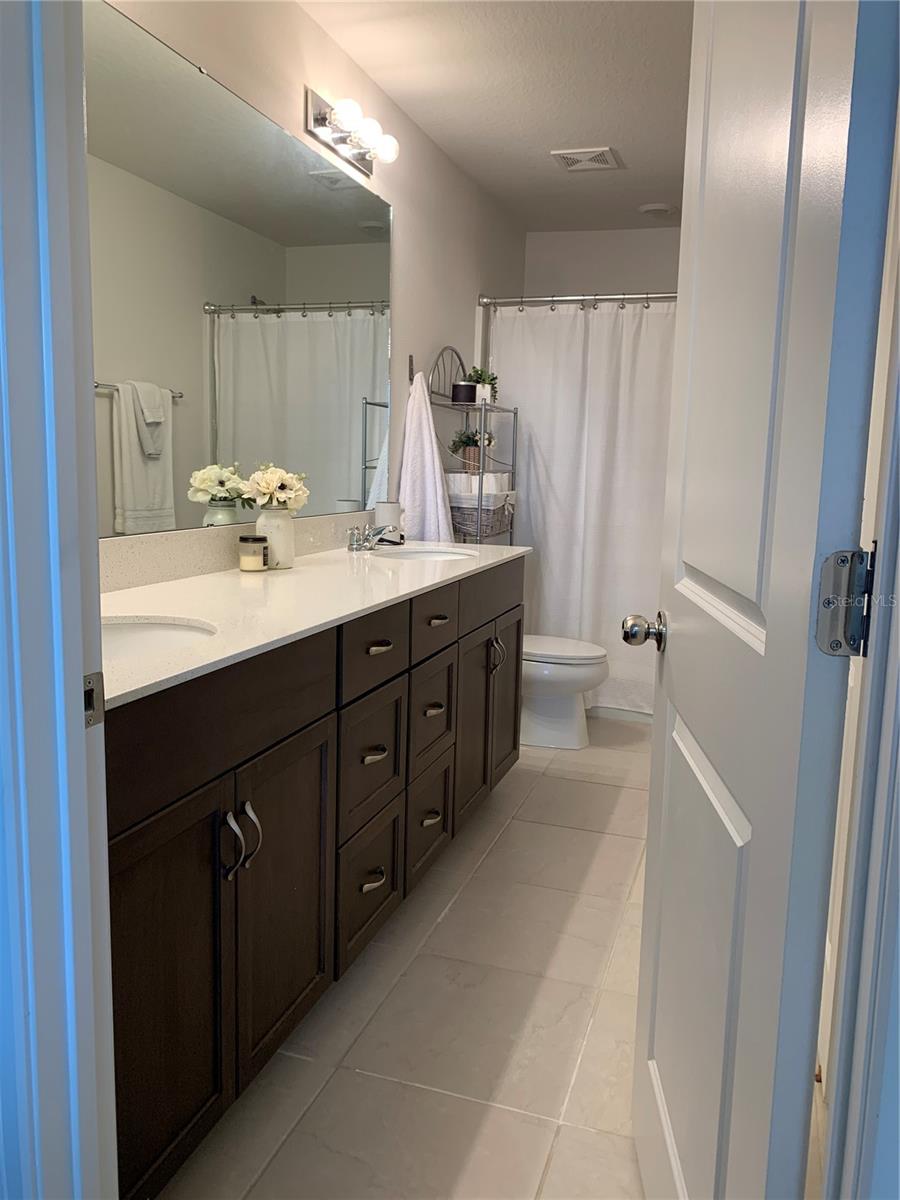 Primary ensuite bathroom with dual sinks and upgraded countertop