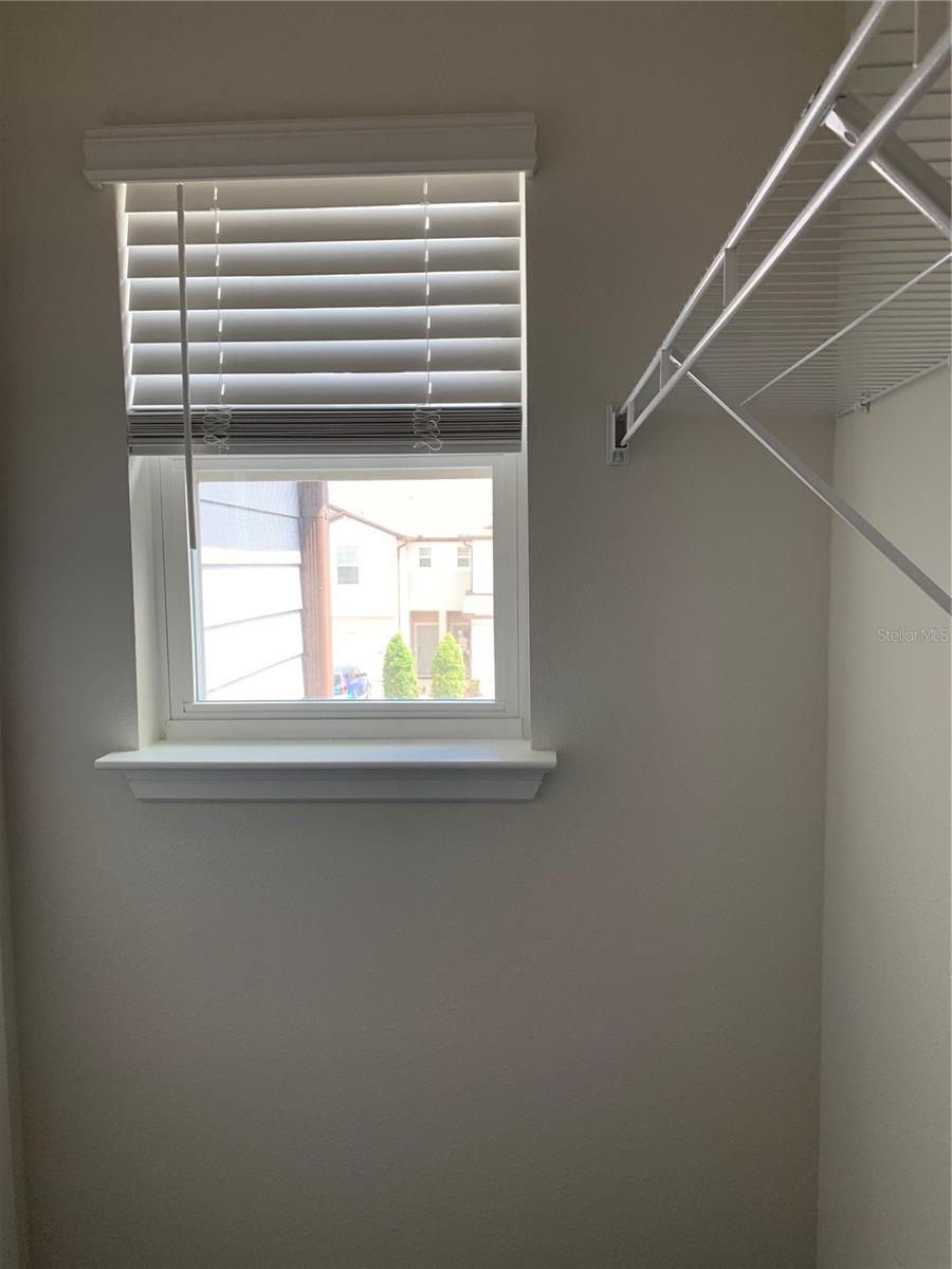 Walk-in closet with a windiow in bedroom 2