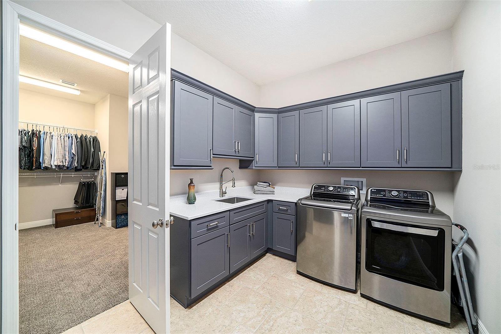 Laundry room with view into primary closet