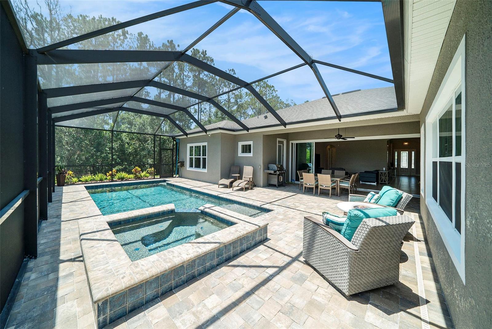 Screened patio with pool and spa looking toward the house