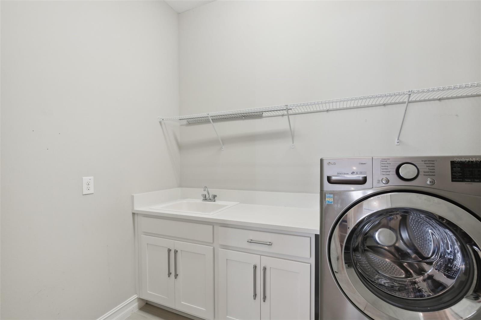 LAUNDRY ROOM HAS CONVENIENT BUILT-IN LAUNDRY TUB WITH STORAGE