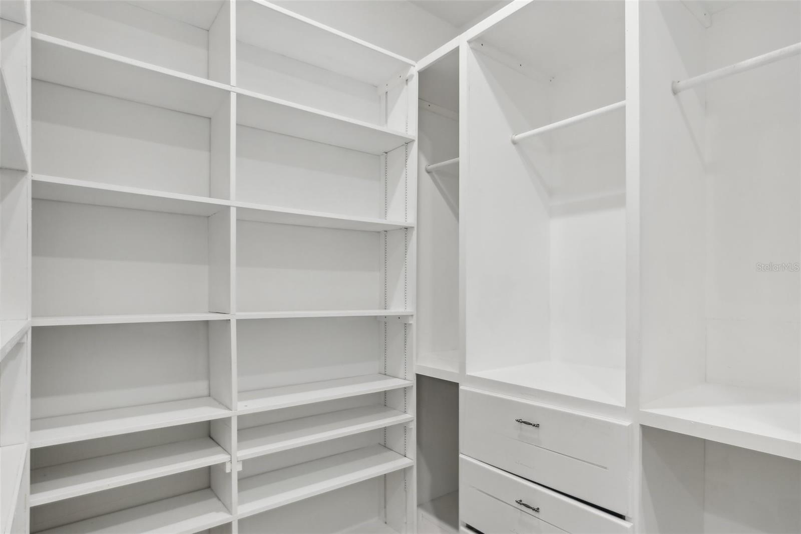 PRIMARY WALK-IN CLOSET HAS ORGANIZED BUILT IN SHELVING
