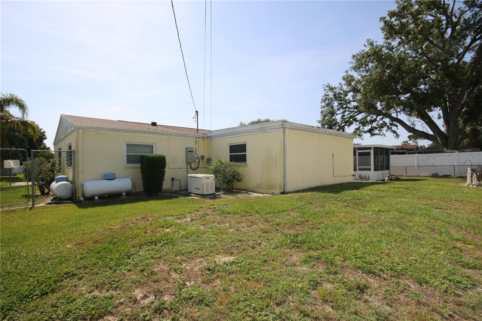 Back of home showing Generac and Propane Tank