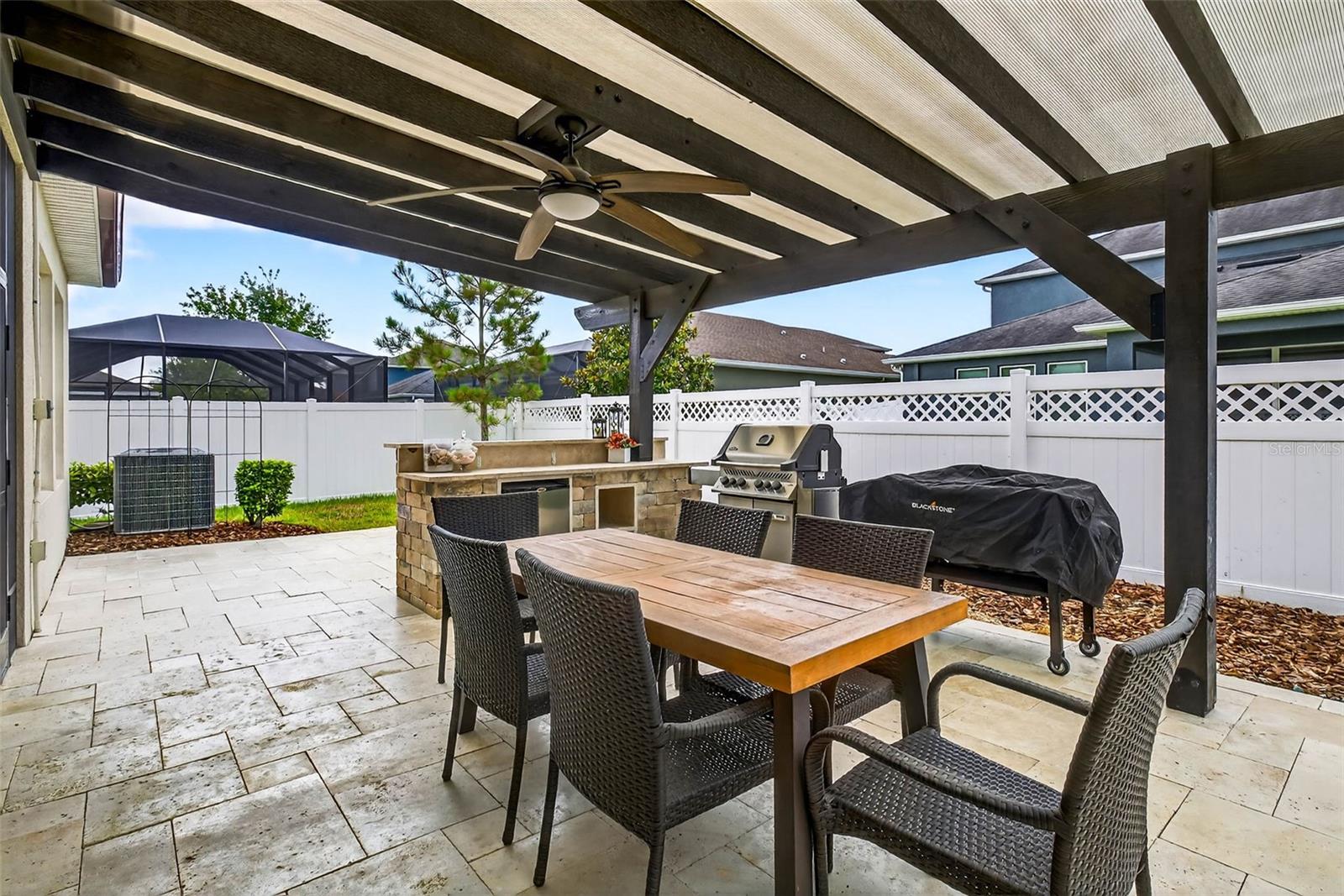 Enjoy Florida living year round on your travertine patio with pergola & outdoor kitchen!