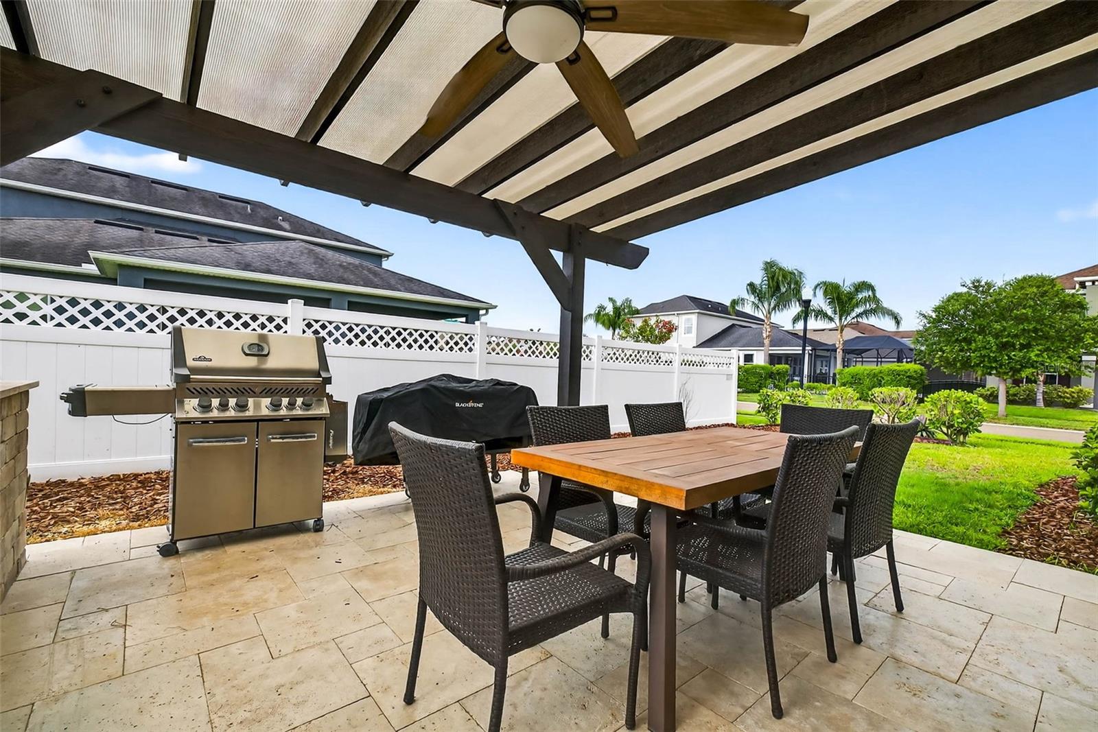 Outdoor travertine patio with pergola and built in outdoor kitchen