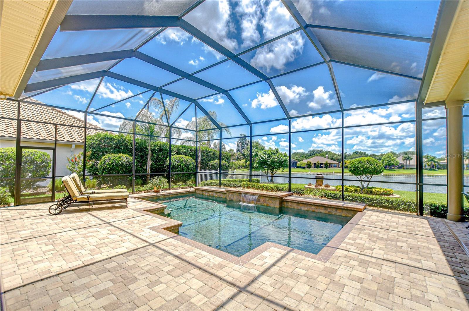 Pool Deck Overlooking Lush Backyard and Lake