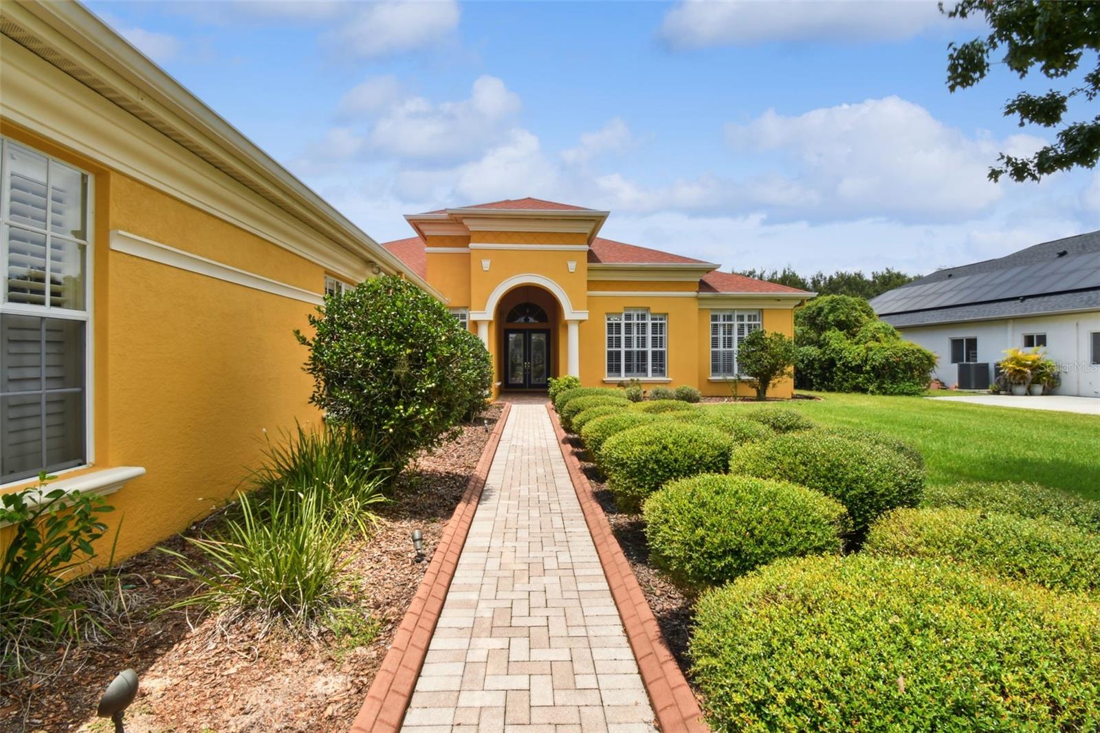 Paver pathway and decorative curbing towards the front of the home.
