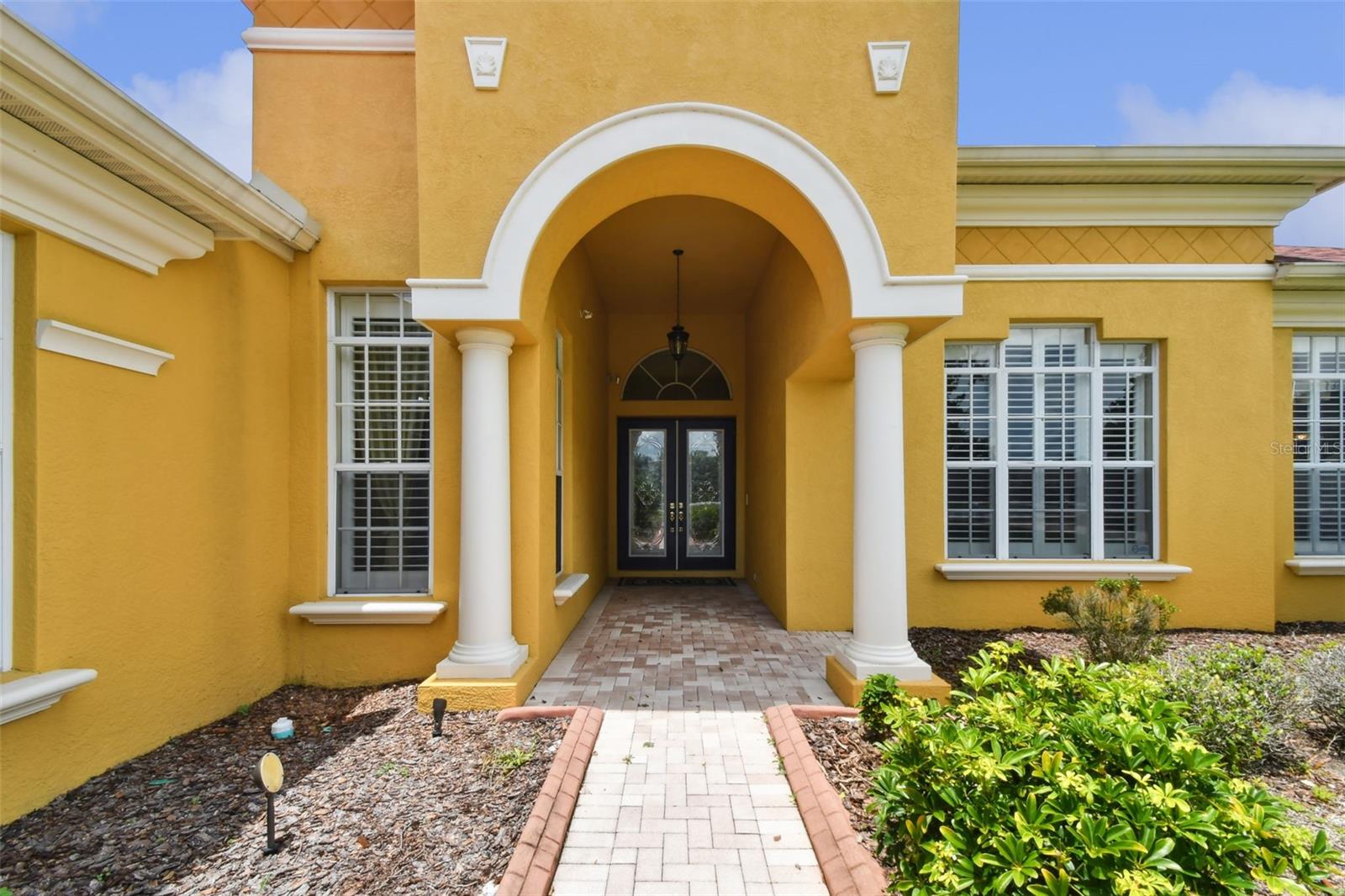 Front entrance with decorative leaded glass front doors.