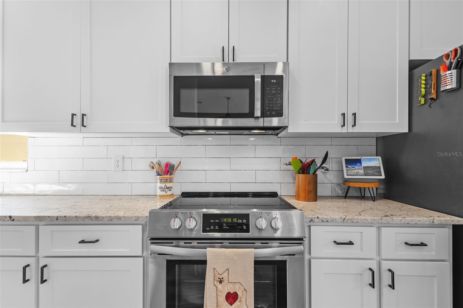 SUBWAY TILE BACKSPLASH, MODERN STAINLESS APPLIANCES AND CRISP WHITE CABINETS