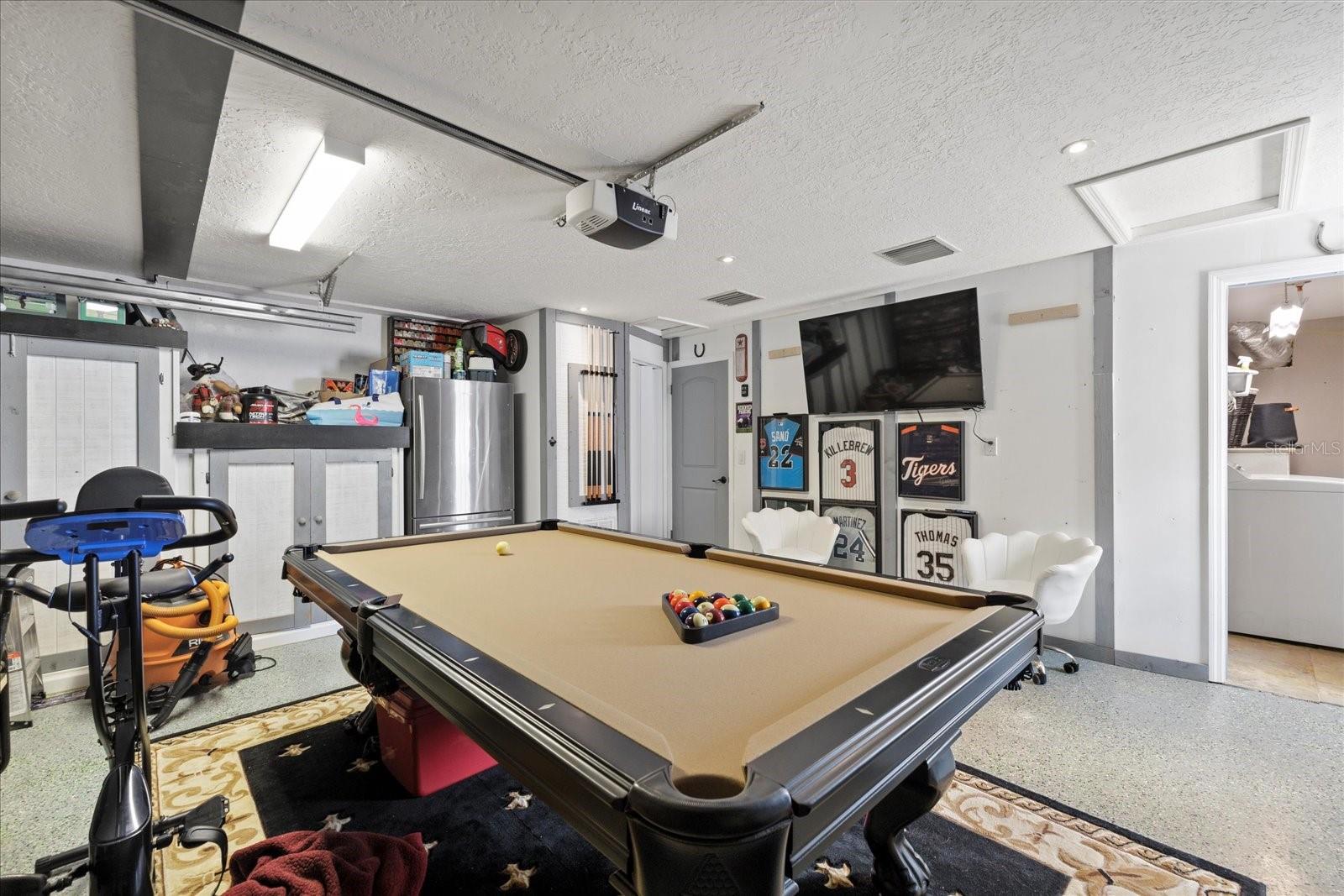 Garage with storage cabinets and stainless refrigerator