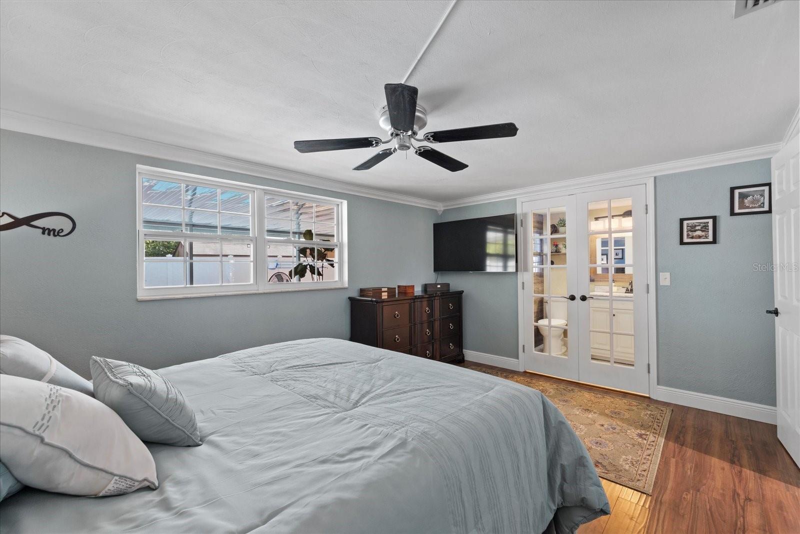 Primary bedroom with view of french doors to bathroom