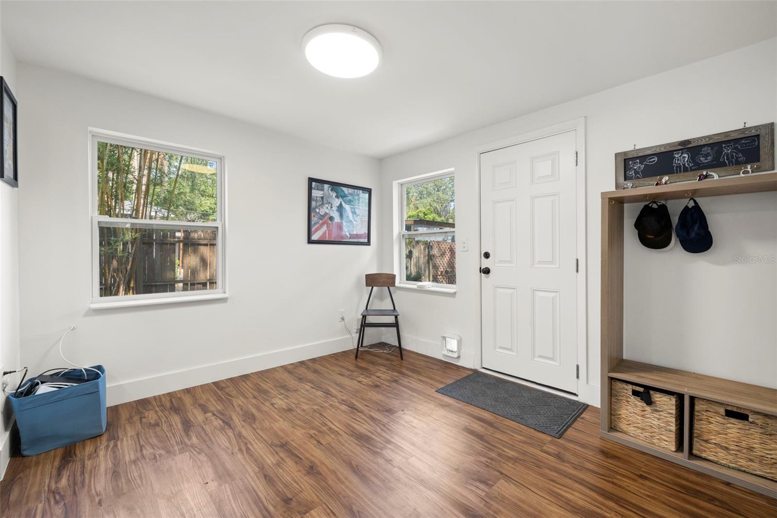 Living room with door to the backyard, garage and alley beyond.