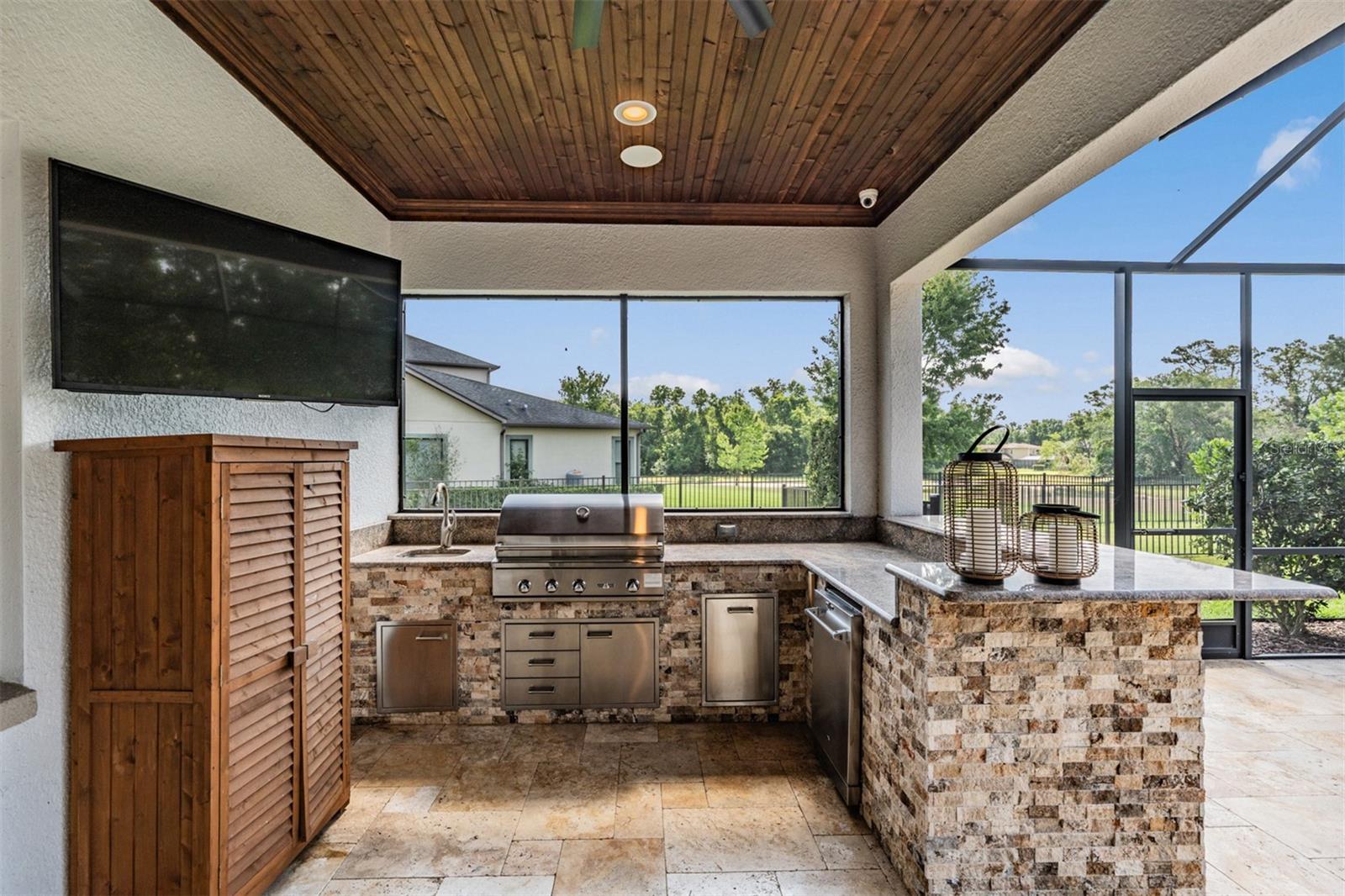 Outdoor kitchen with wood planked ceiling