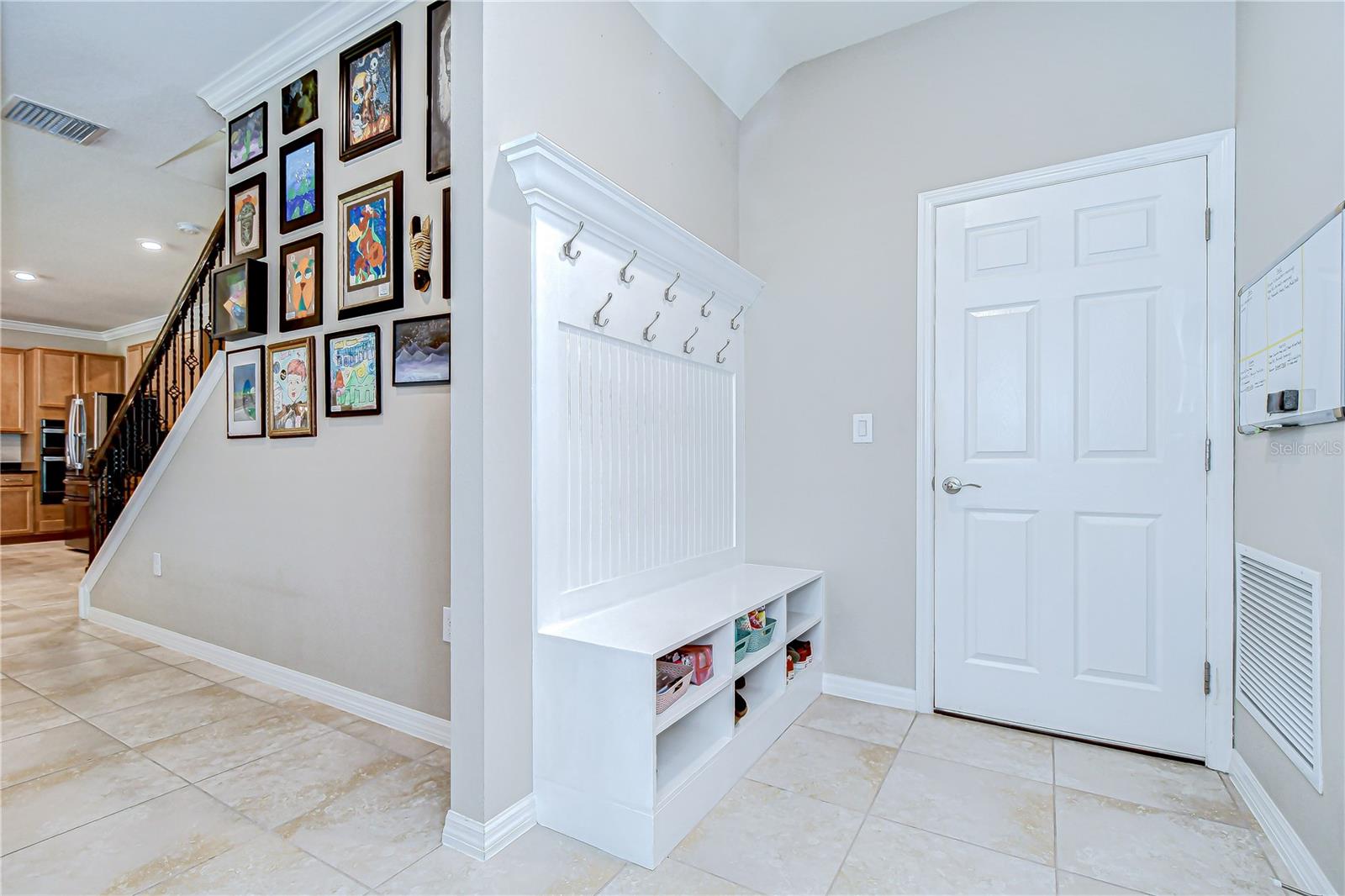 A mudroom with built-in cabinetry leads to the 3-car garage,